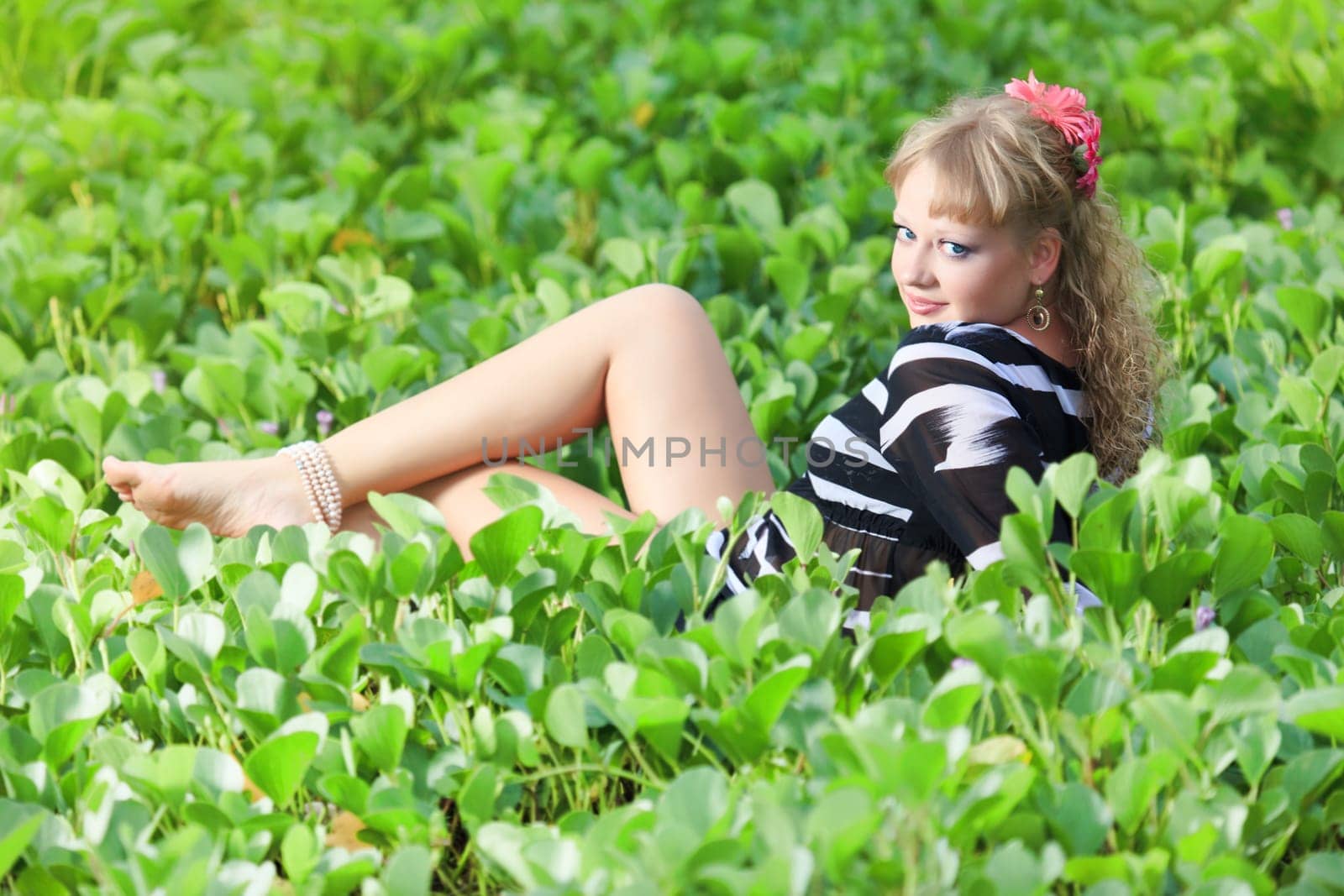 Beautiful woman in grass with gerbera flowers