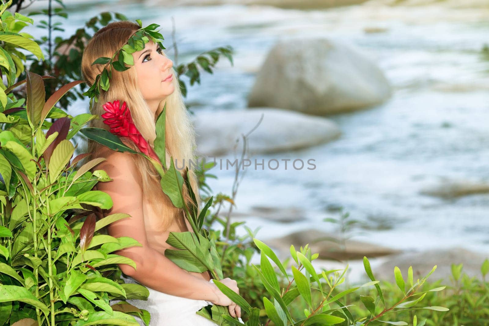 Beautiful woman as a forest nymph on the river