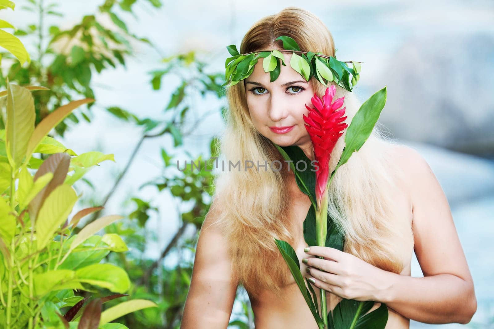Beautiful woman as a forest nymph on the river