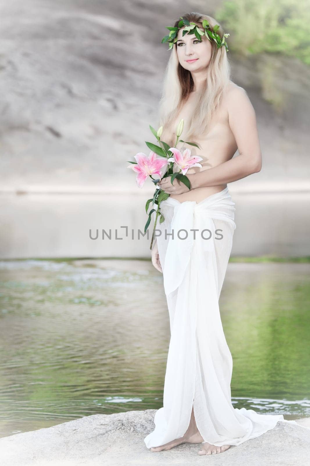 Beautiful woman as a forest nymph on the river