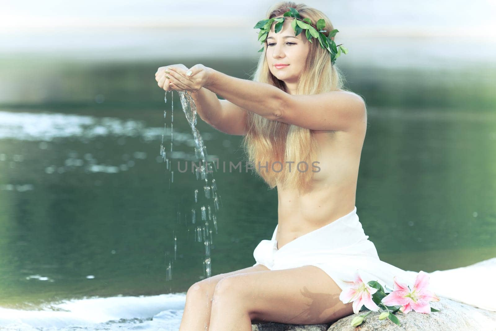 Beautiful woman as a forest nymph on the river