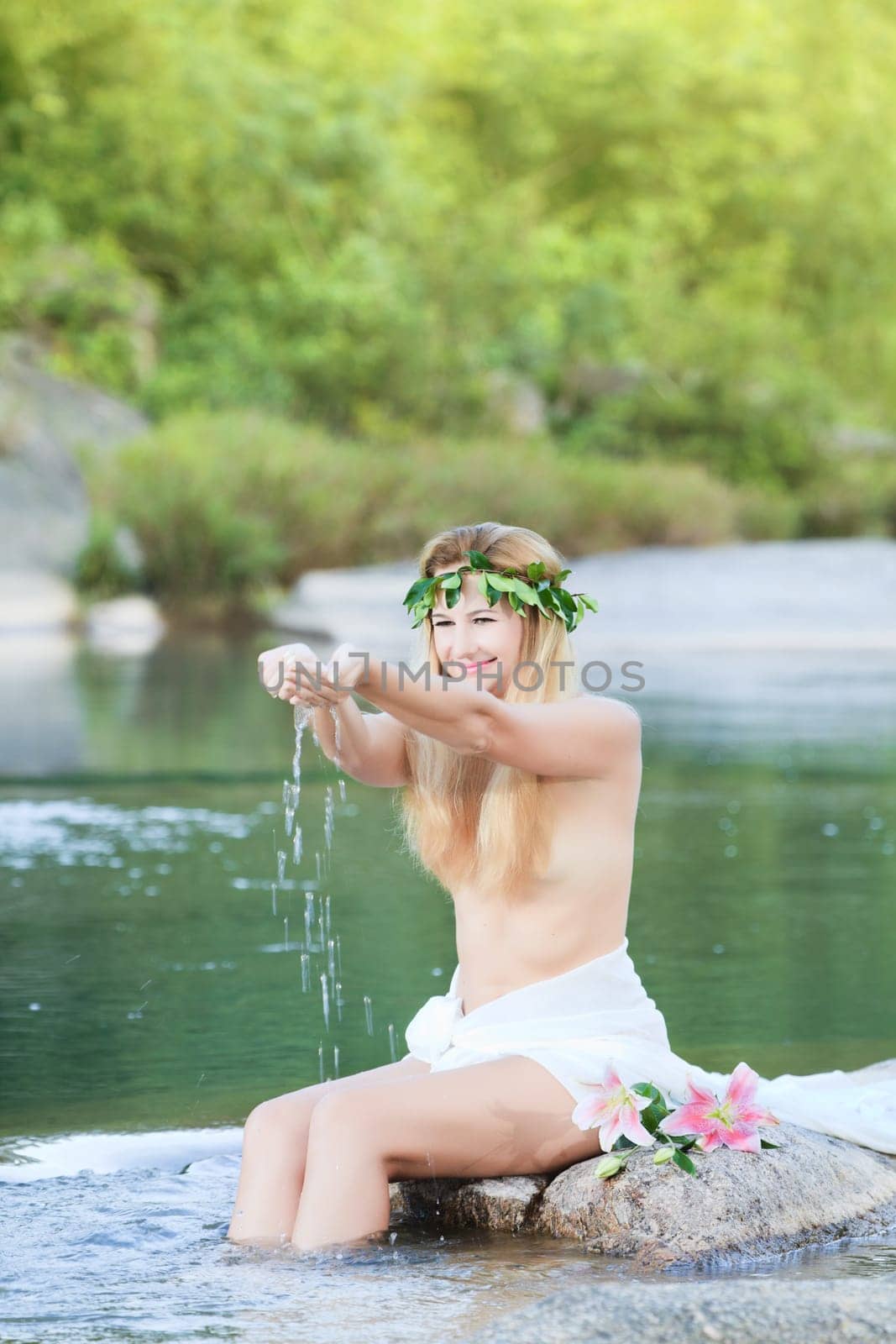 Beautiful woman as a forest nymph on the river