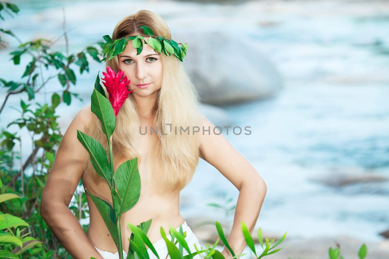 Beautiful woman as a forest nymph on the river