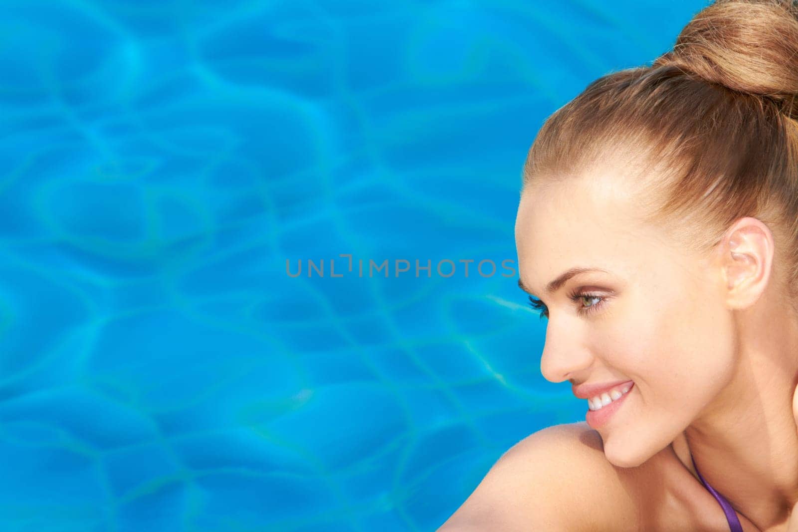 Portrait of smiling beauty on pool blue water background