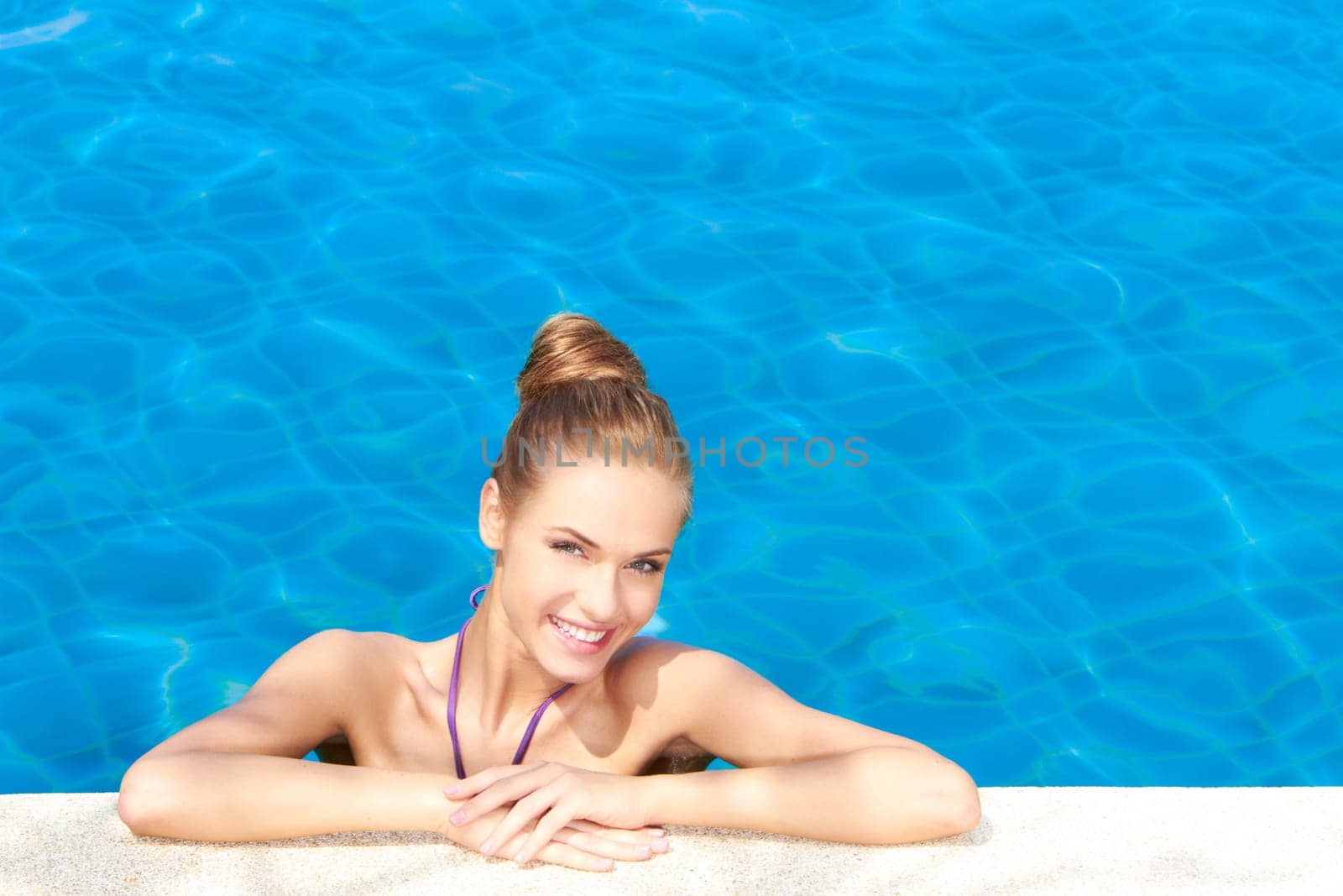 Cute girl in swimming pool with copy space