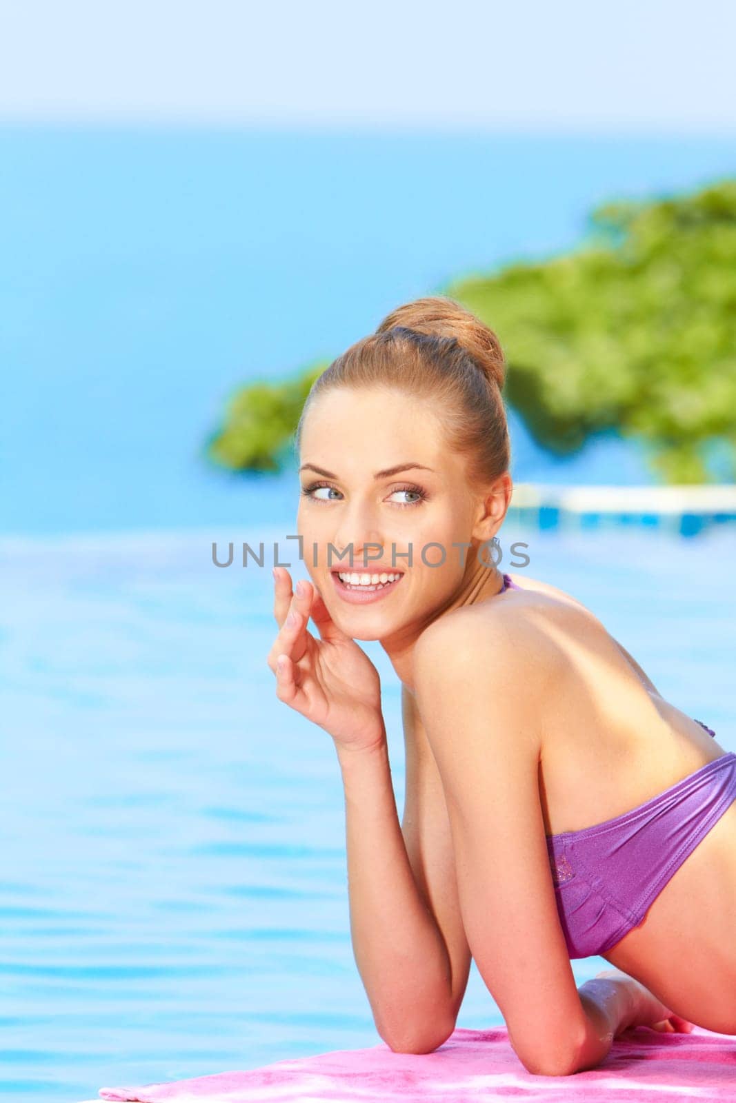 Young woman in swimsuit lying close to swimming pool
