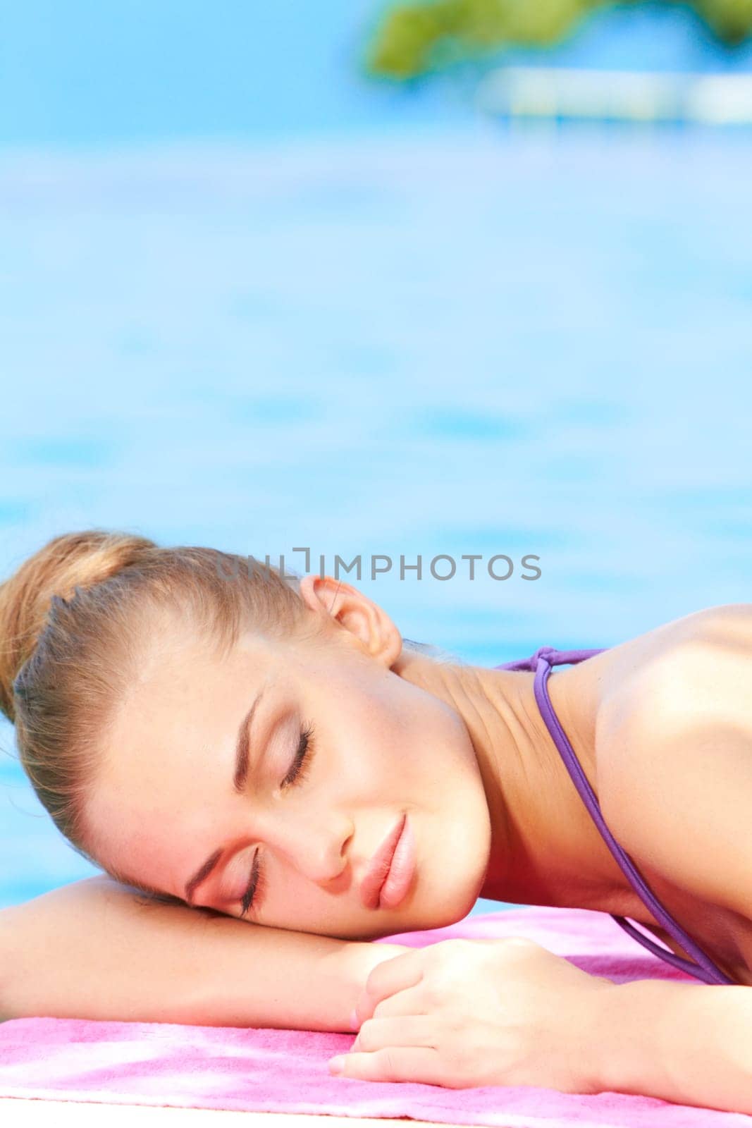 Young beautiful woman sleeping next to swimming pool