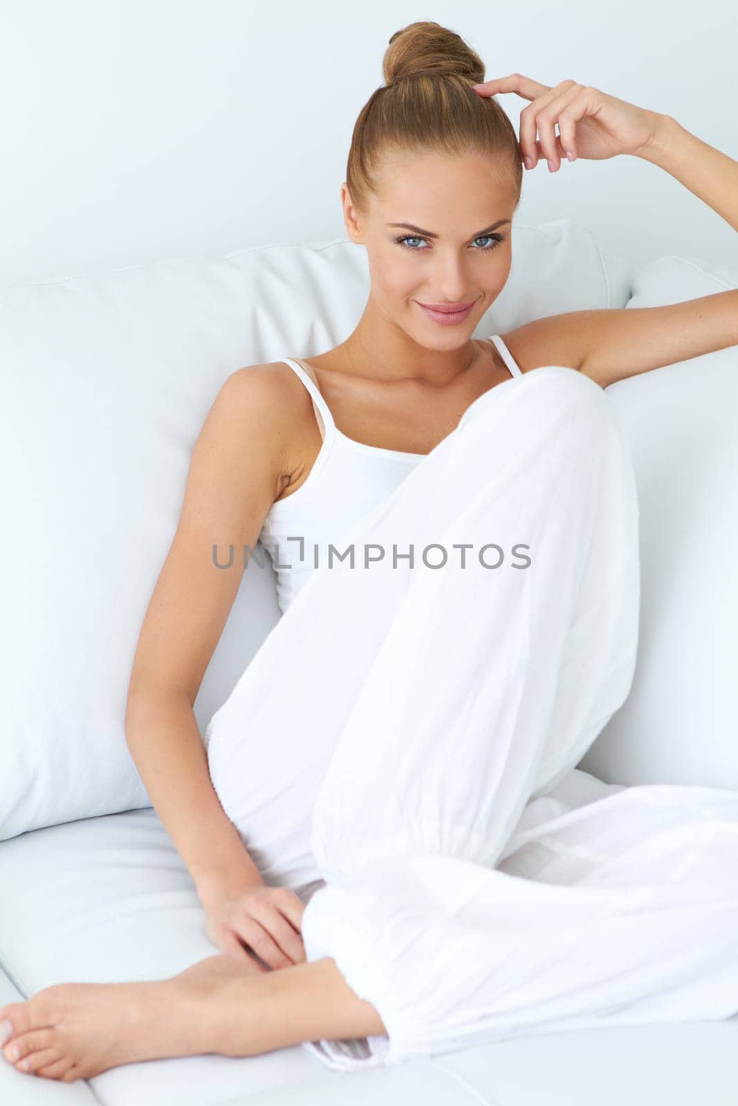 Young beautiful woman sitting on couch at her room