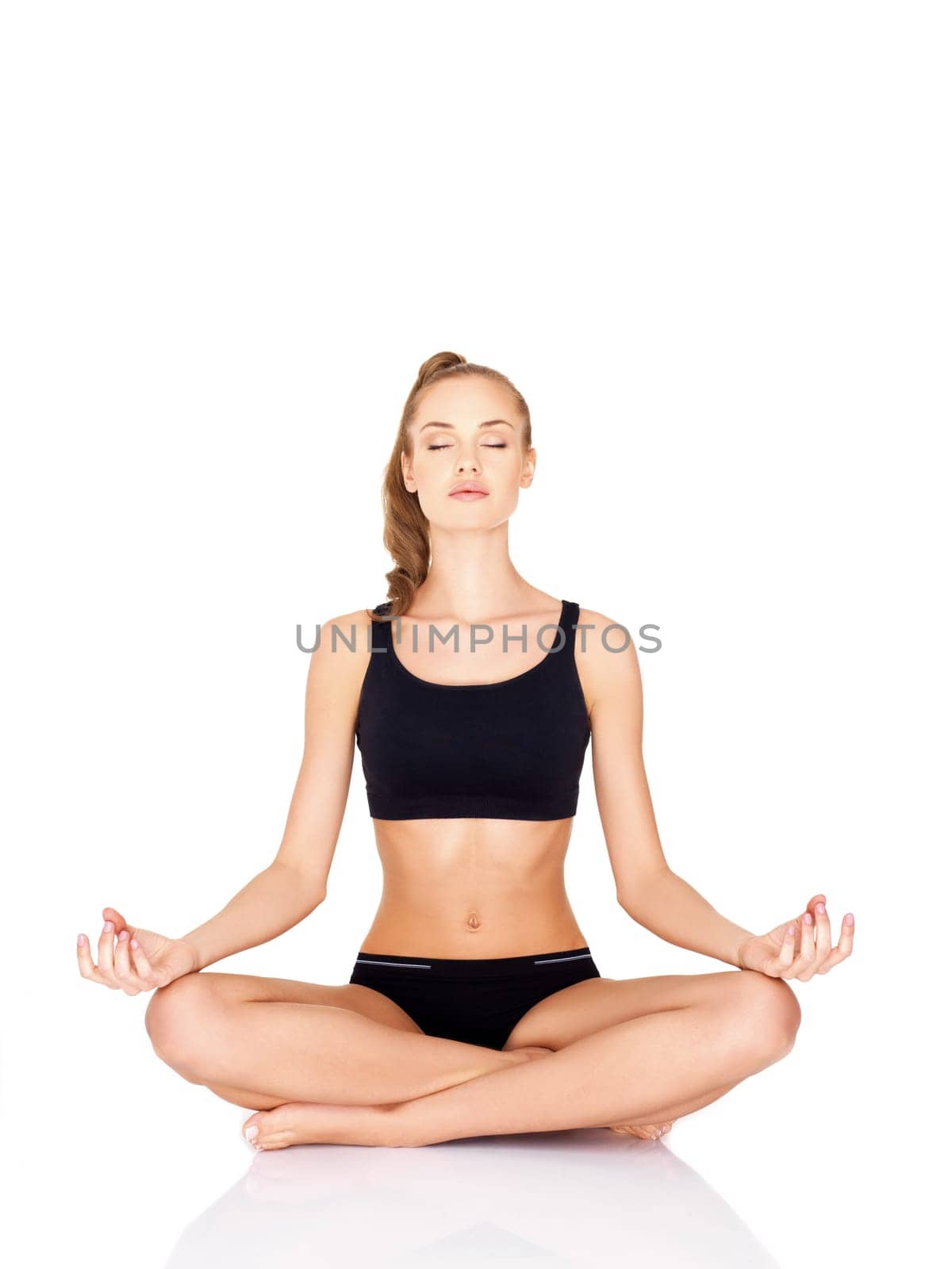 Portrait of pretty young woman doing yoga on white