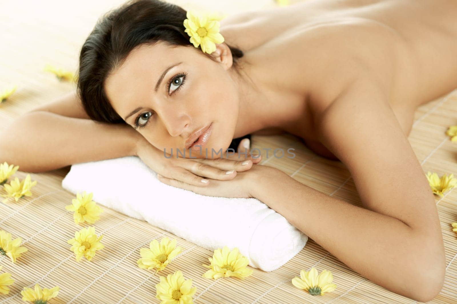 Portrait of Fresh and Beautiful brunette woman laying on bamboo mat around yellow flowers