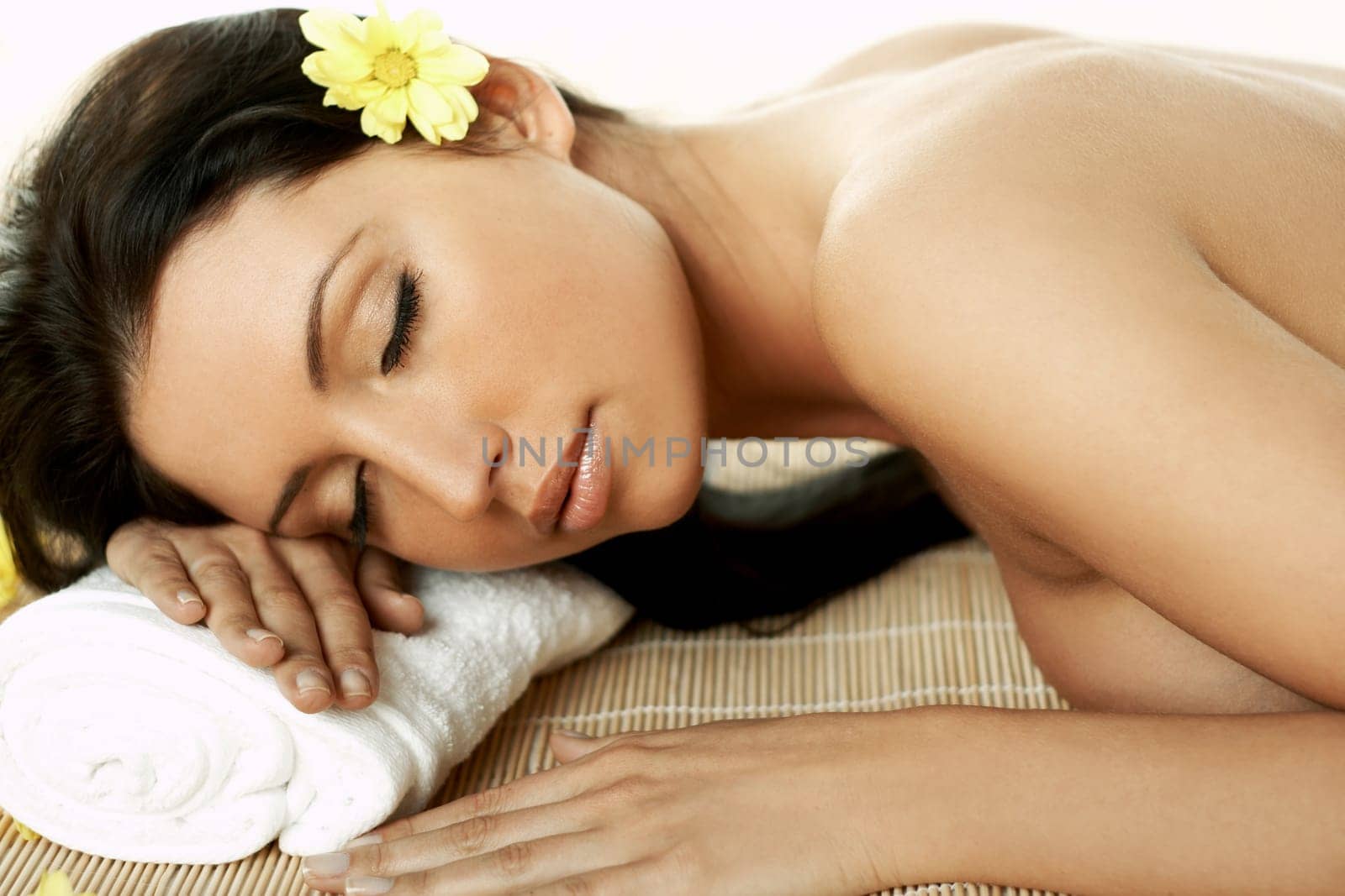 Portrait of Fresh and Beautiful brunette woman laying on bamboo mat around yellow flowers