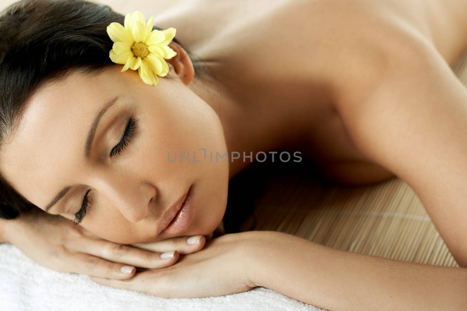 Portrait of Fresh and Beautiful brunette woman laying on bamboo mat around yellow flowers