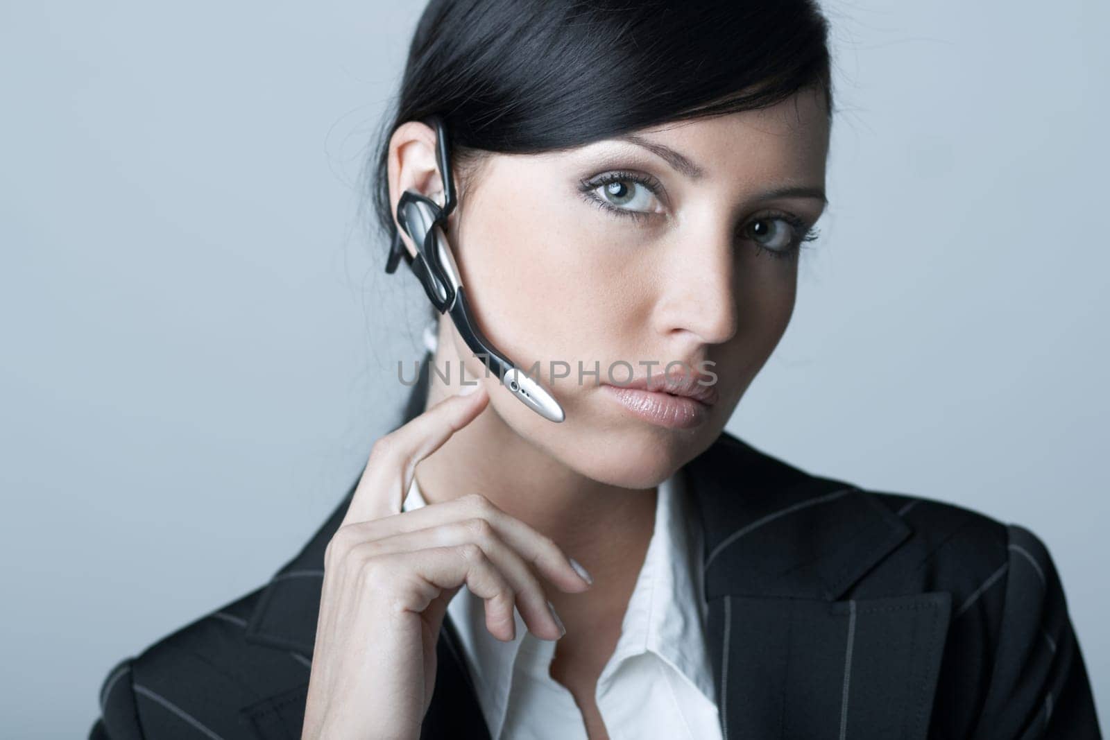 Beautiful brunette business woman with wireless headset isolated on clear background