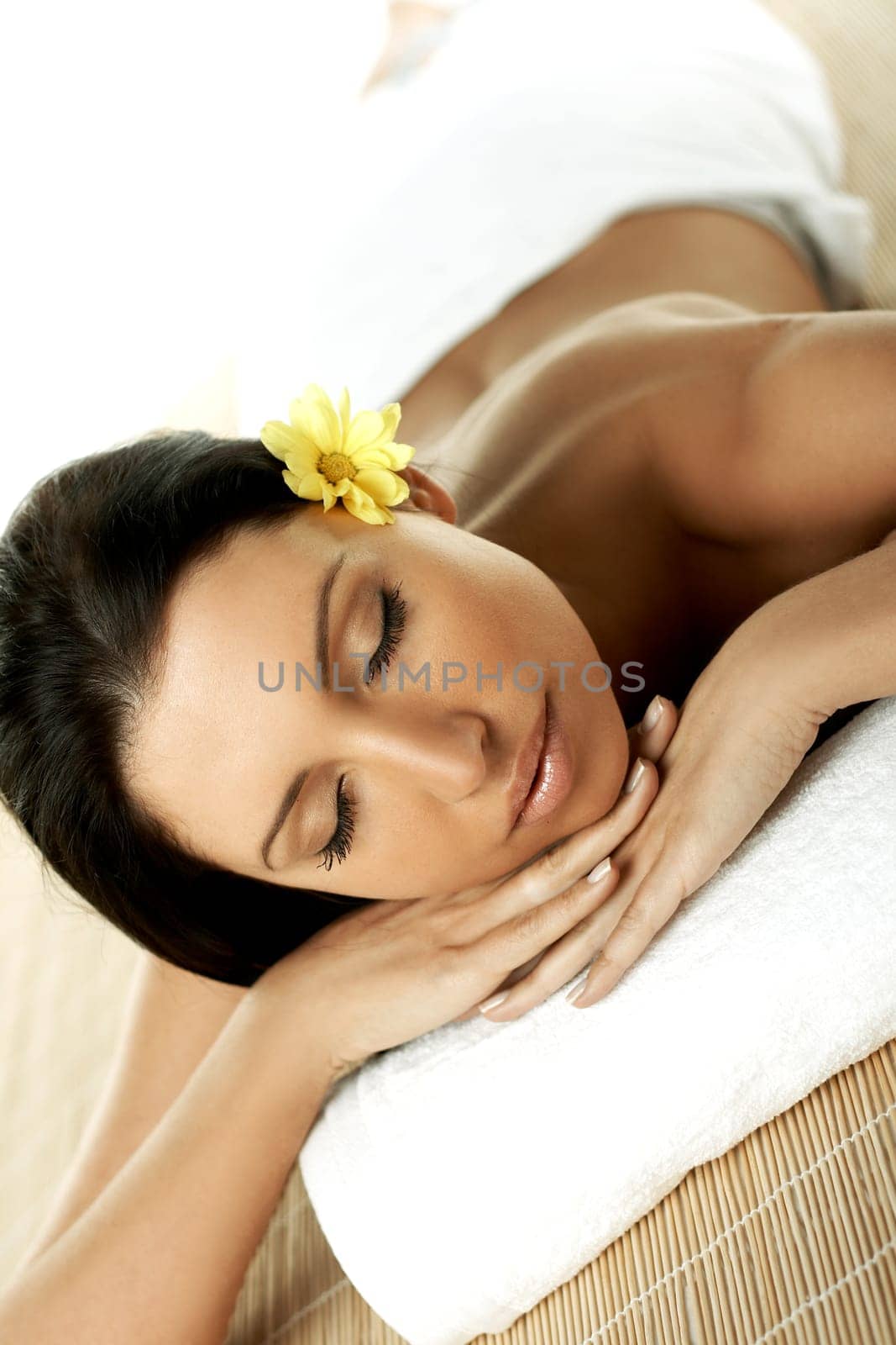 Portrait of Fresh and Beautiful brunette woman laying on bamboo mat around yellow flowers