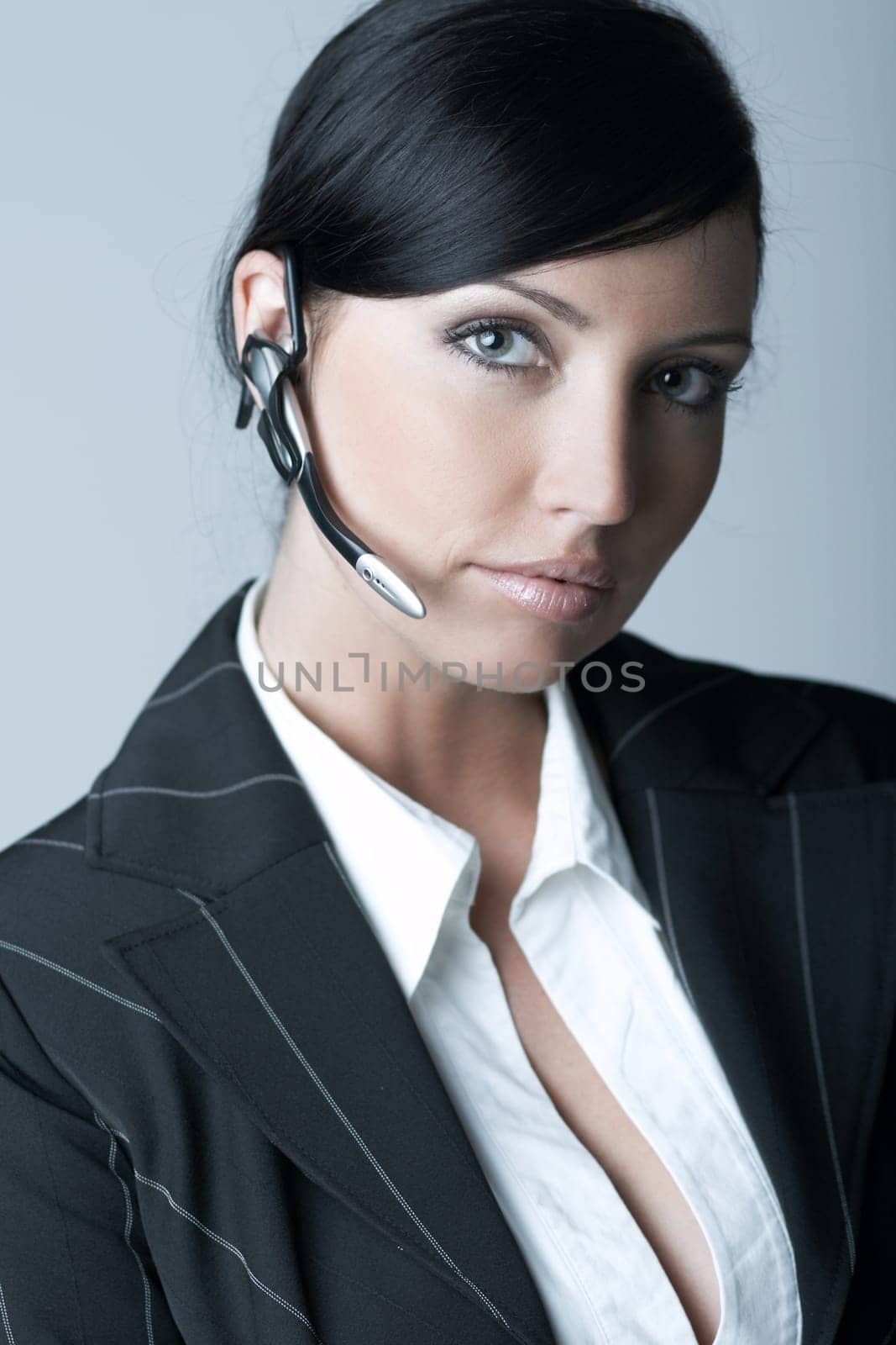 Beautiful brunette business woman with wireless headset isolated on clear background