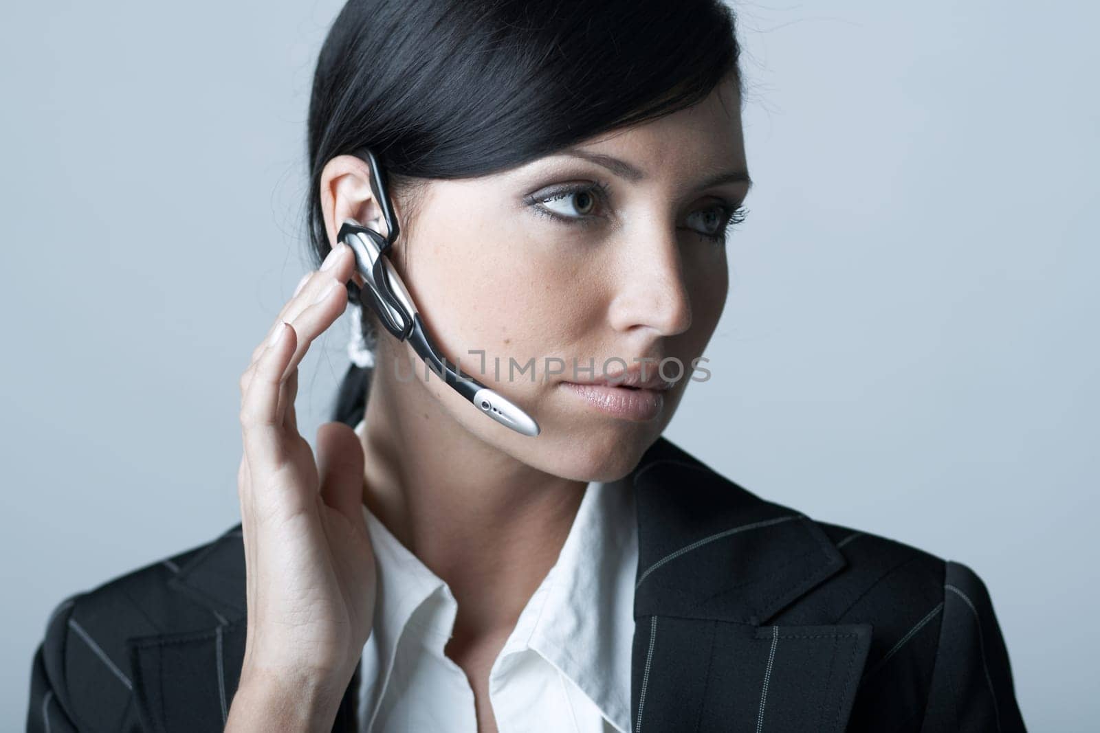 Beautiful and sexy brunette business woman talking telephone. She is isolated on clear background