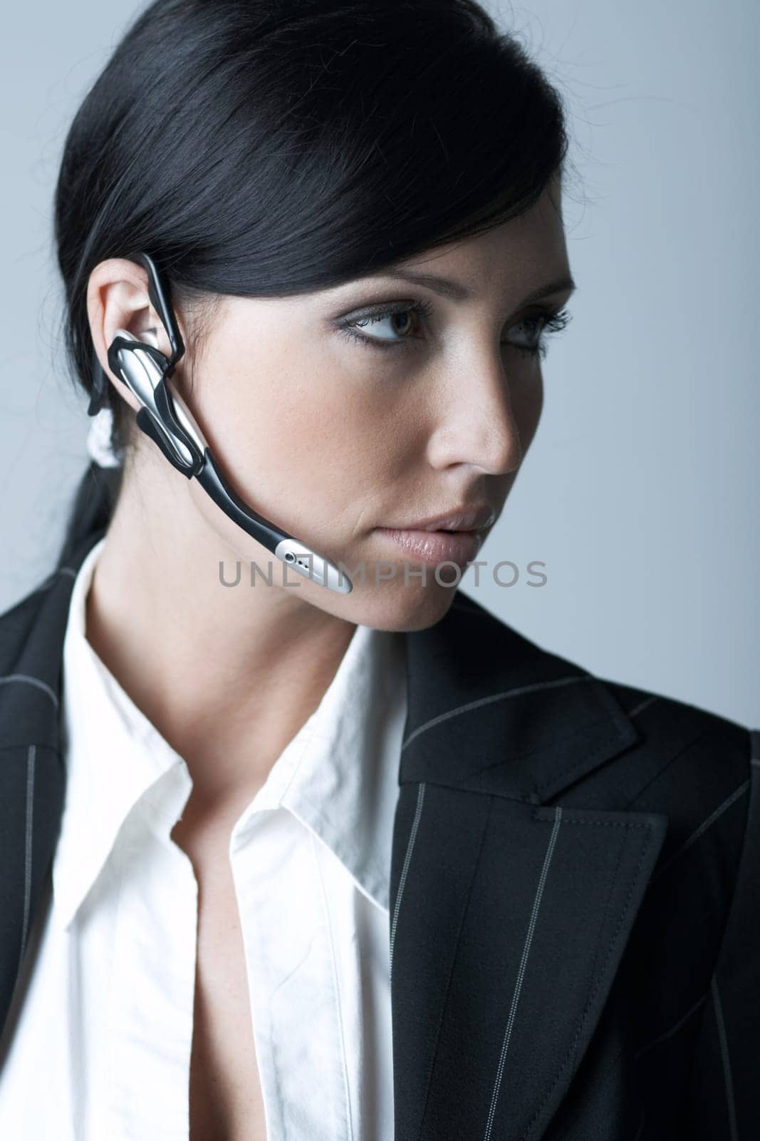 Beautiful brunette business woman with wireless headset isolated on clear background