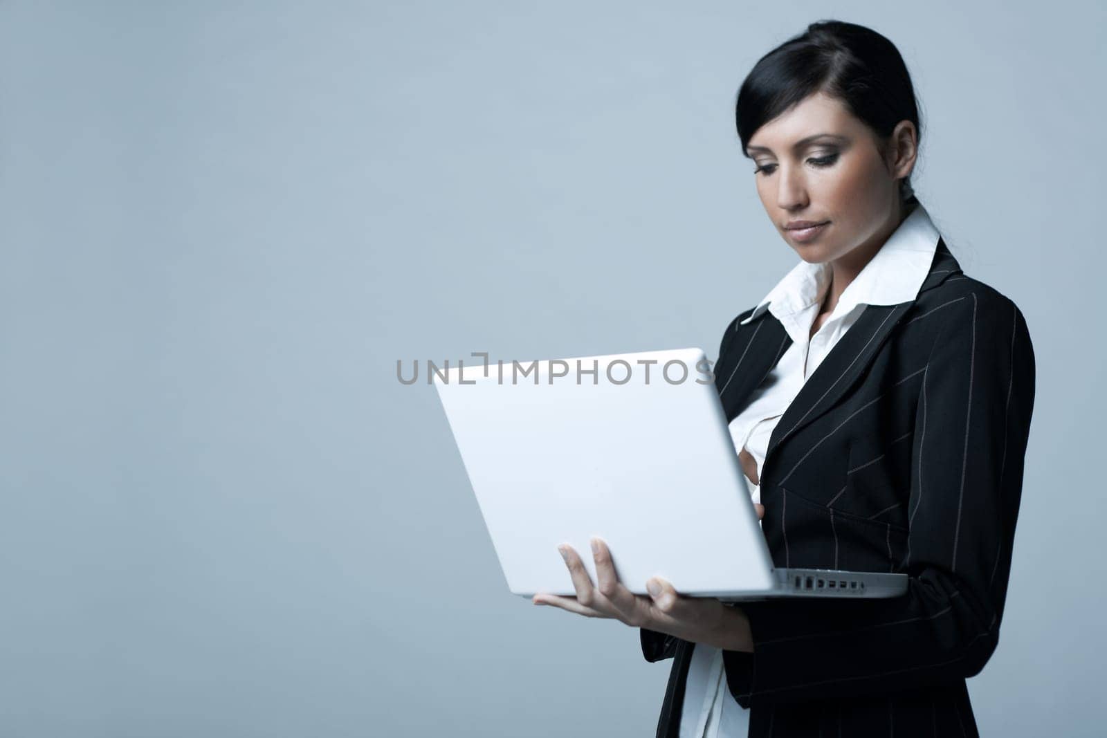 Beautiful brunette business woman with laptop computer isolated on clear background