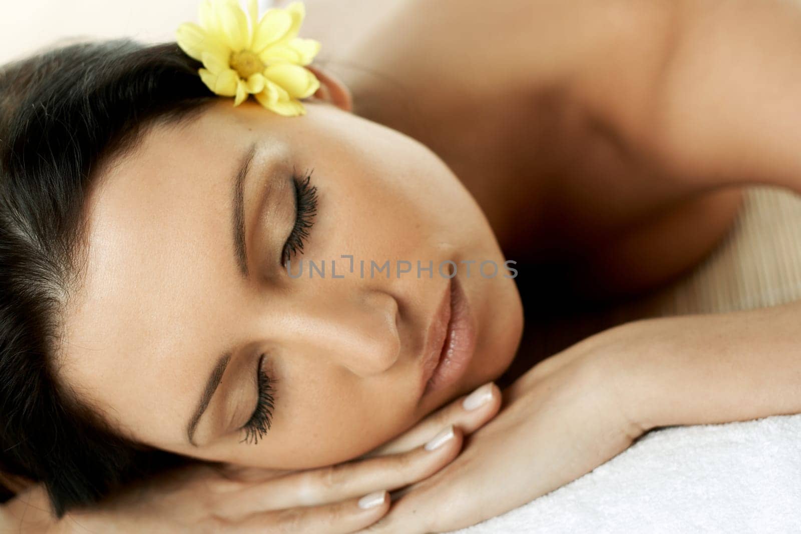 Portrait of Fresh and Beautiful brunette woman laying on bamboo mat around yellow flowers