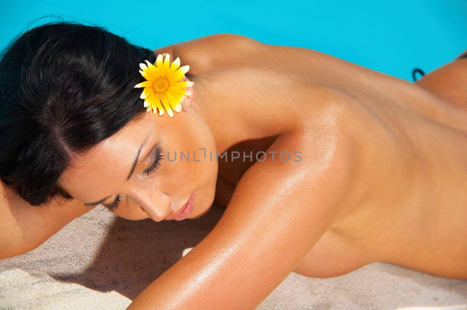 Beautiful young Sexy woman laying in bikini during sunbath next to swimming pool
