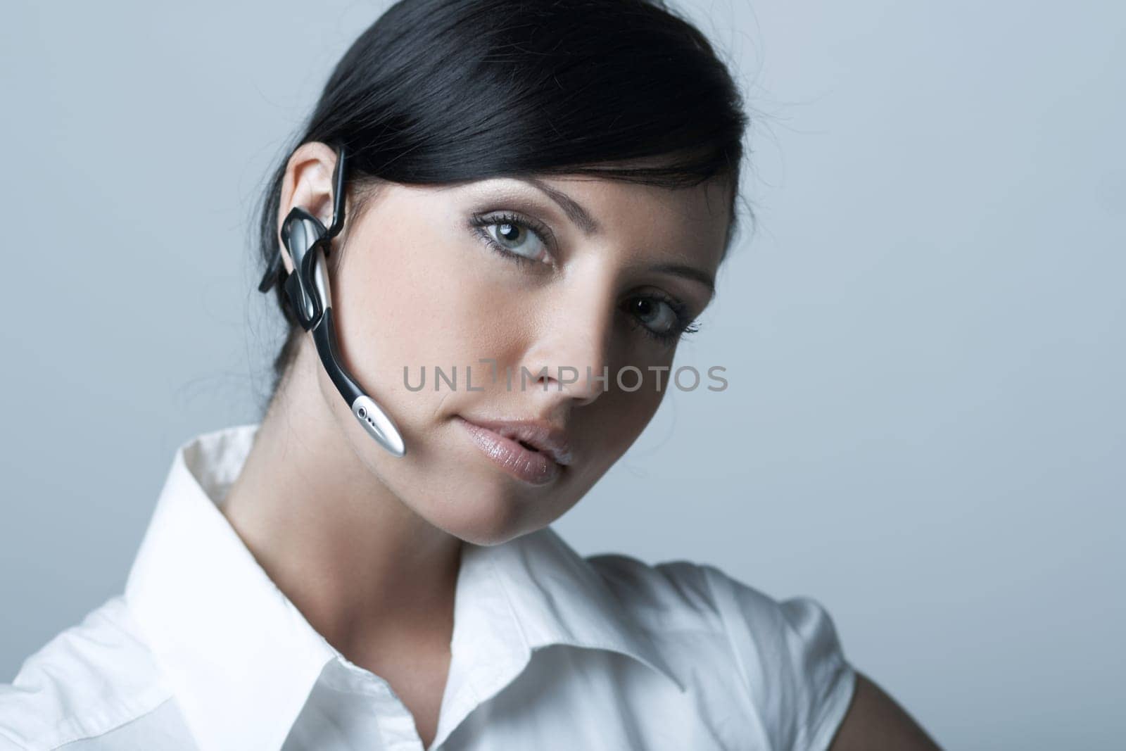 Beautiful brunette business woman with wireless headset isolated on clear background