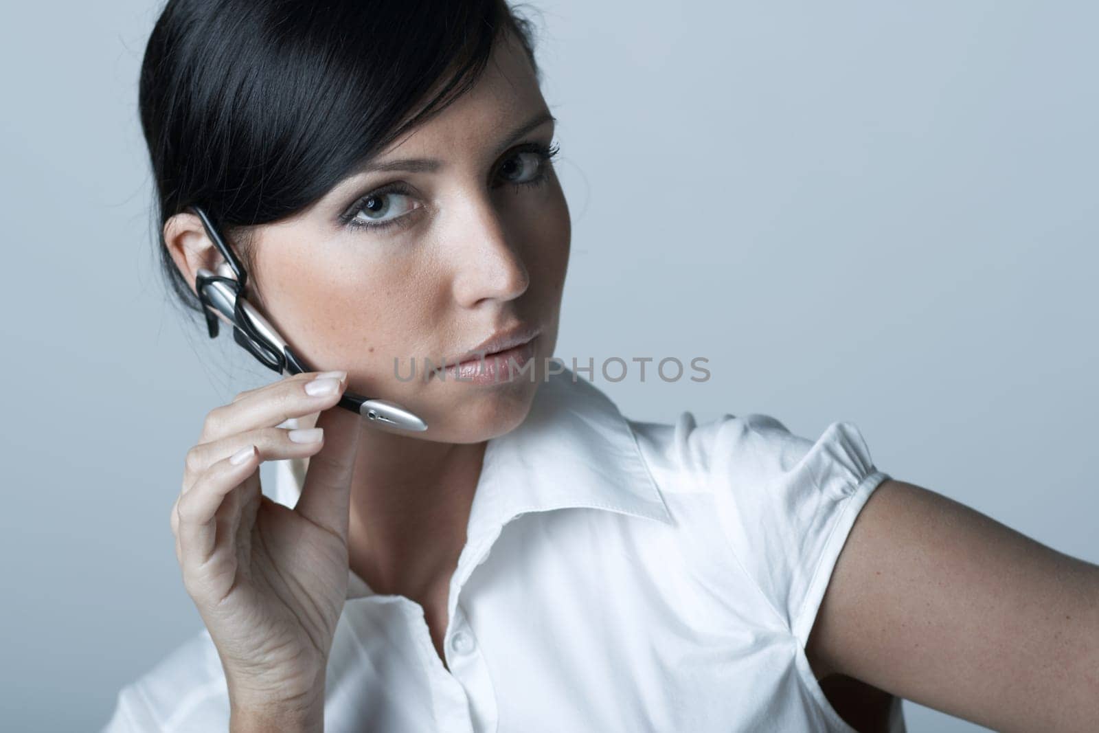 Beautiful and sexy brunette business woman talking telephone. She is isolated on clear background
