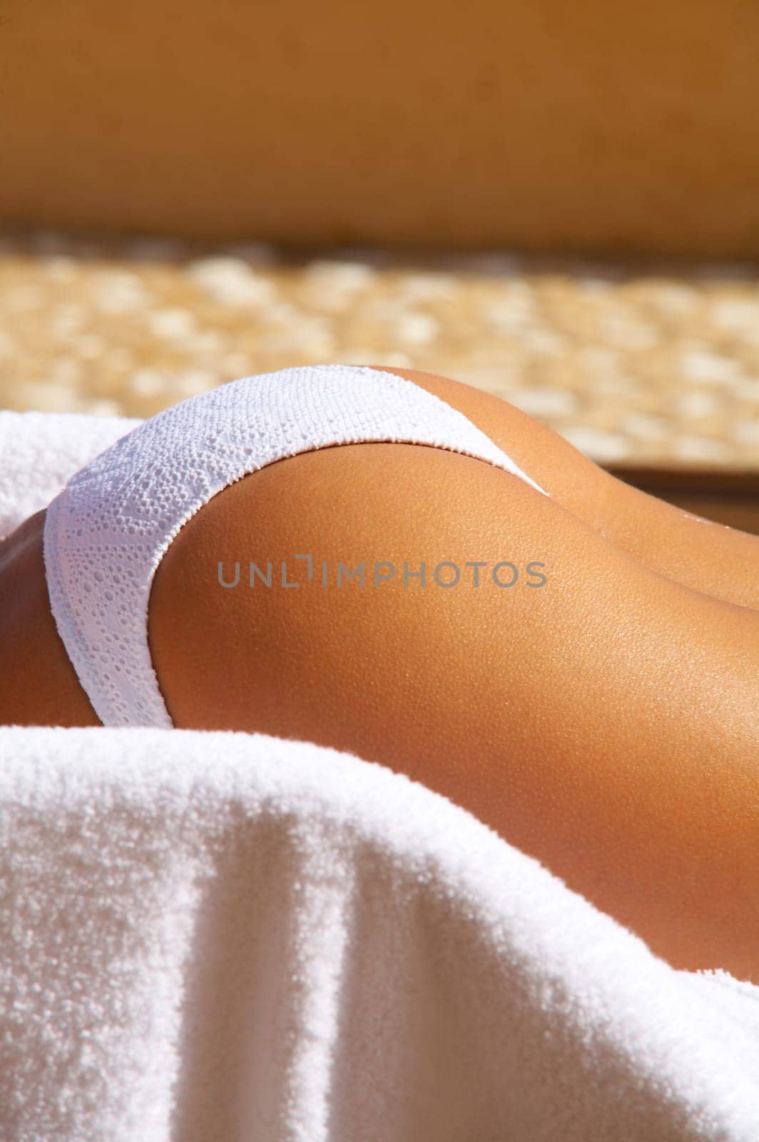 Sexy womans body part in bikini during sunbath laying on deckchair