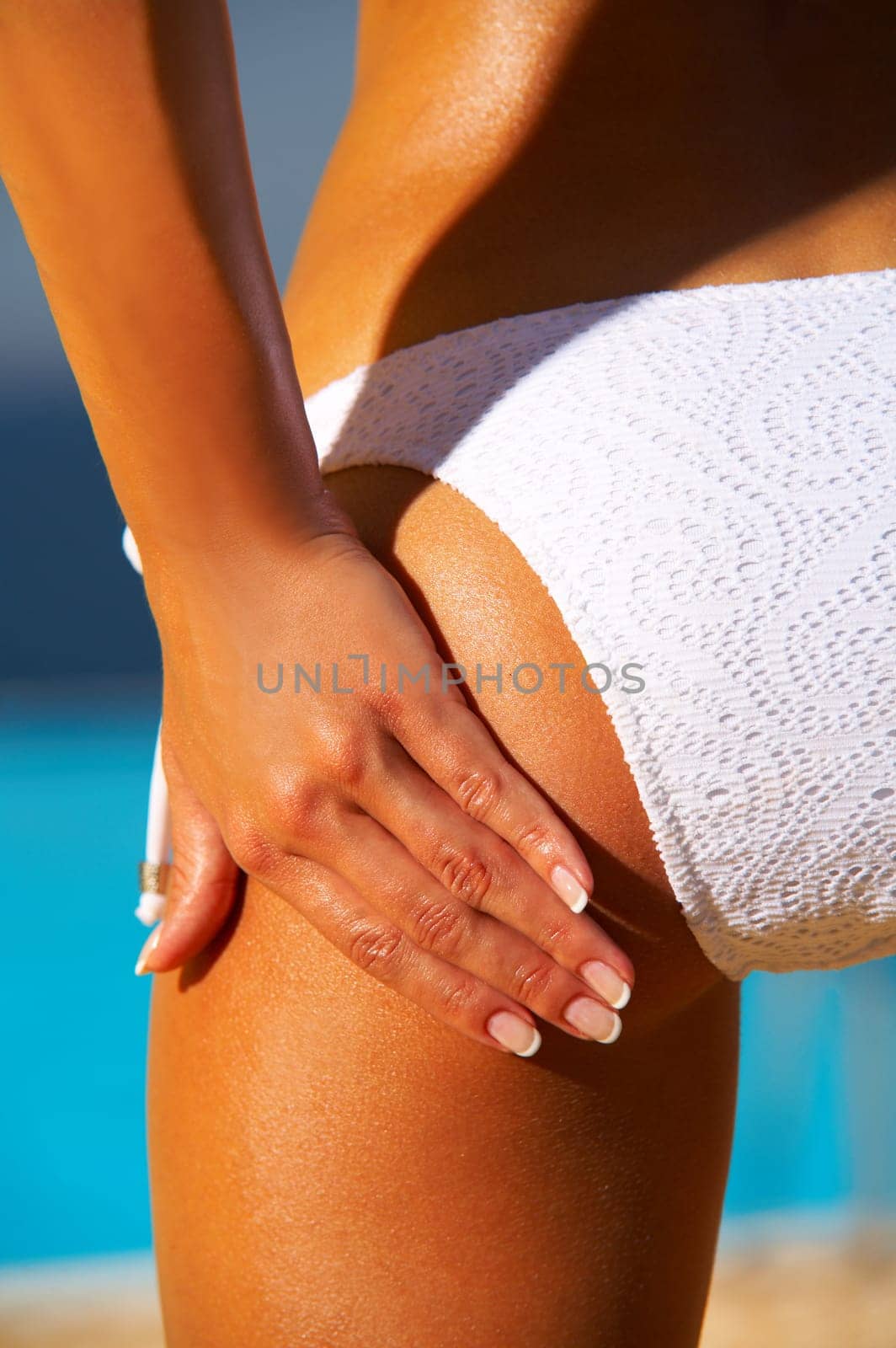 Beautiful young Sexy woman body in bikini during sunbath next to swimming pool