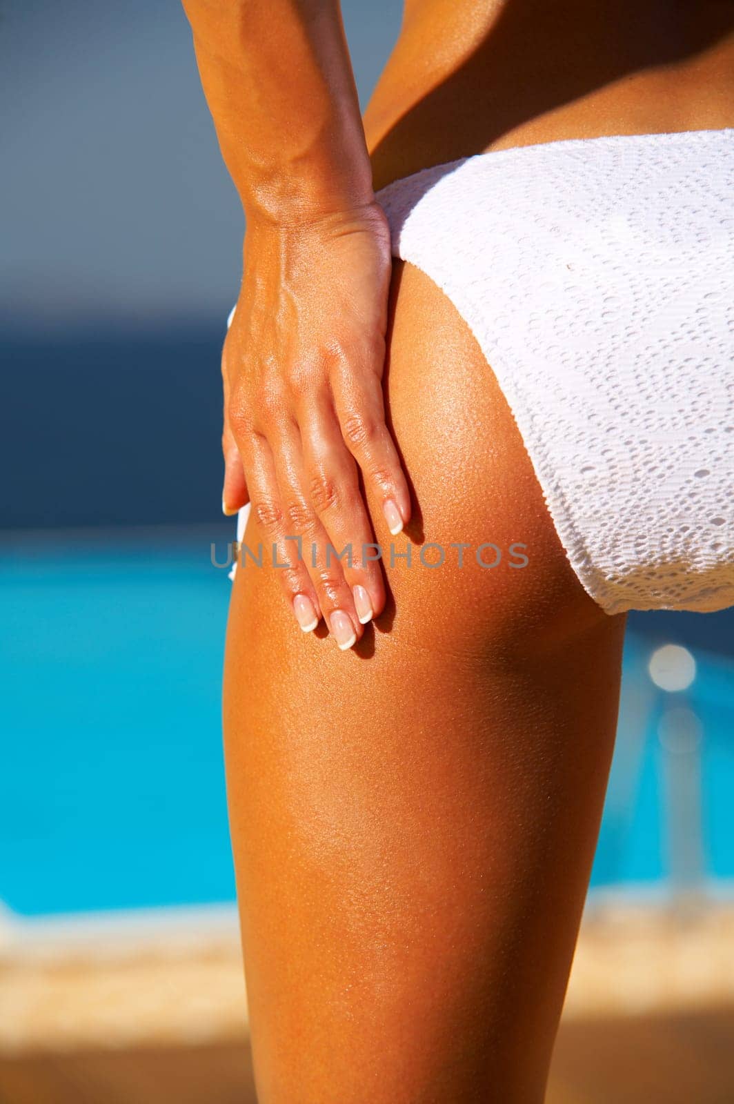Beautiful young Sexy woman body in bikini during sunbath next to swimming pool