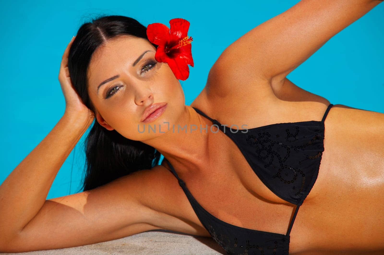 Beautiful young Sexy woman laying in bikini during sunbath next to swimming pool