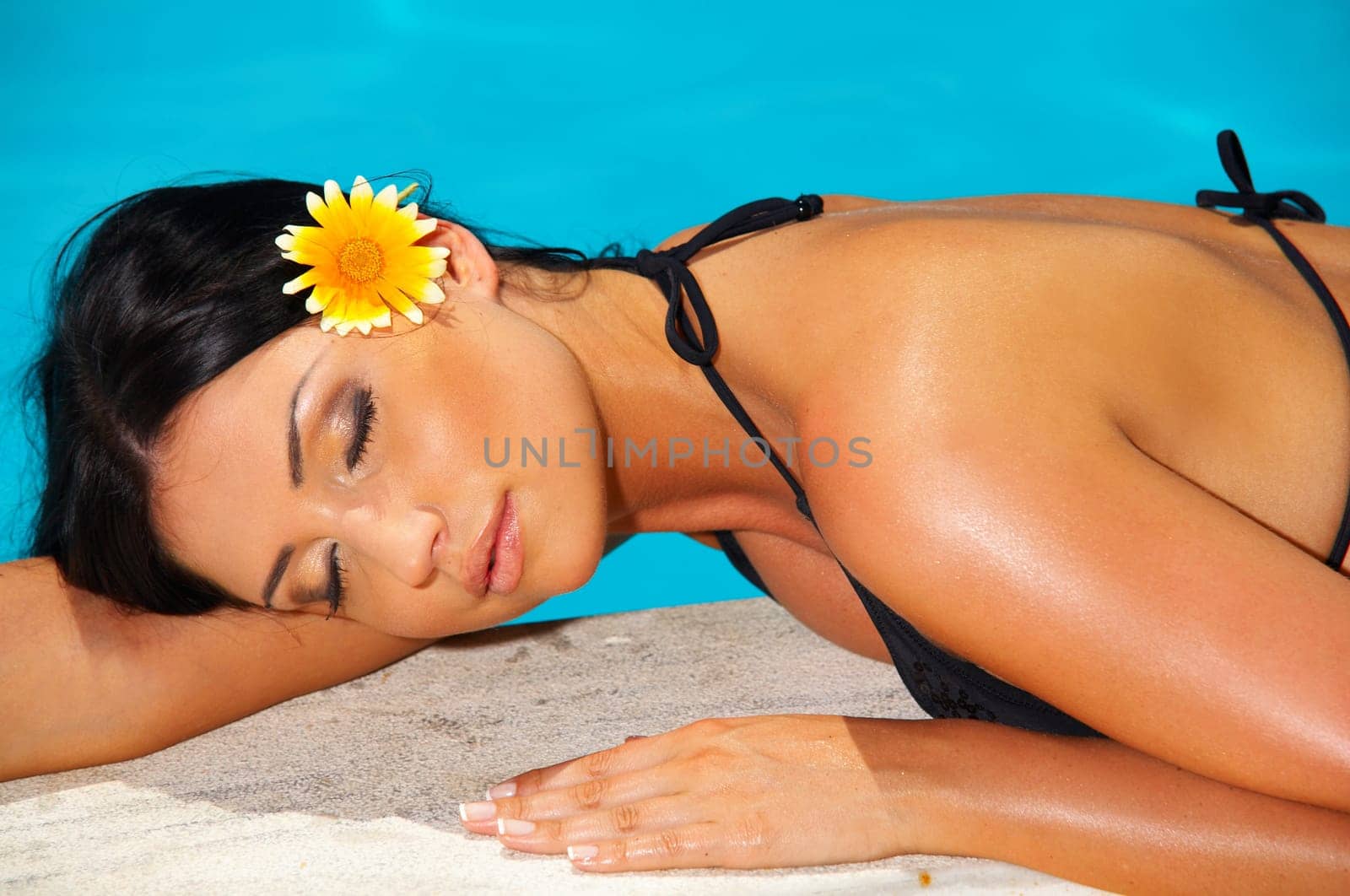 Beautiful young Sexy woman laying in bikini during sunbath next to swimming pool