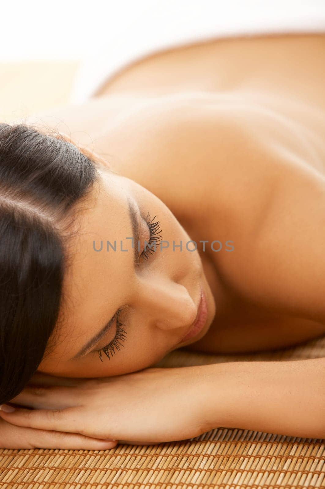Portrait of Fresh and Beautiful brunette woman laying on bamboo mat