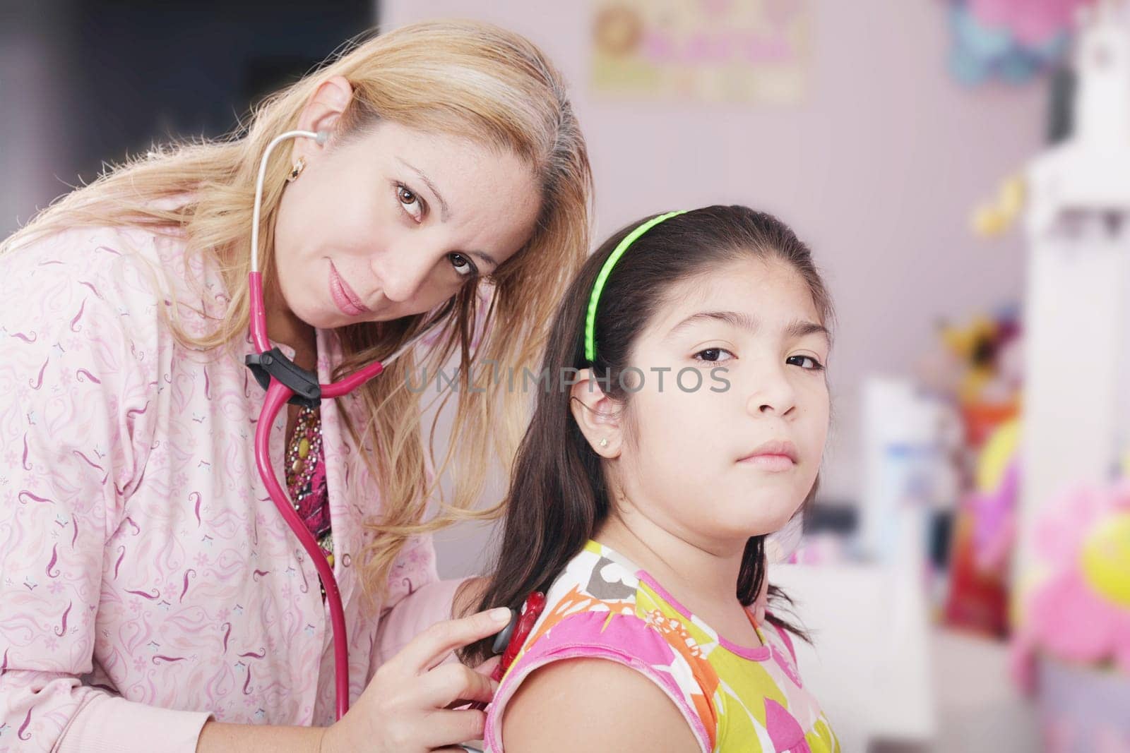Pediatrician examining little girl with stethoscope