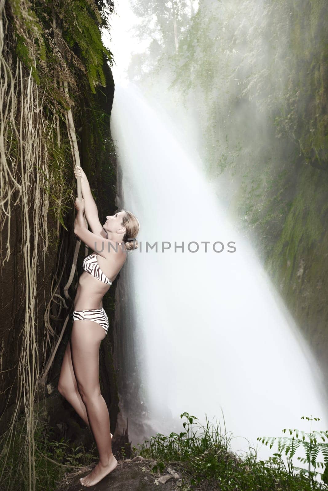 Beaurtiful woman posing near the Blawan waterfall