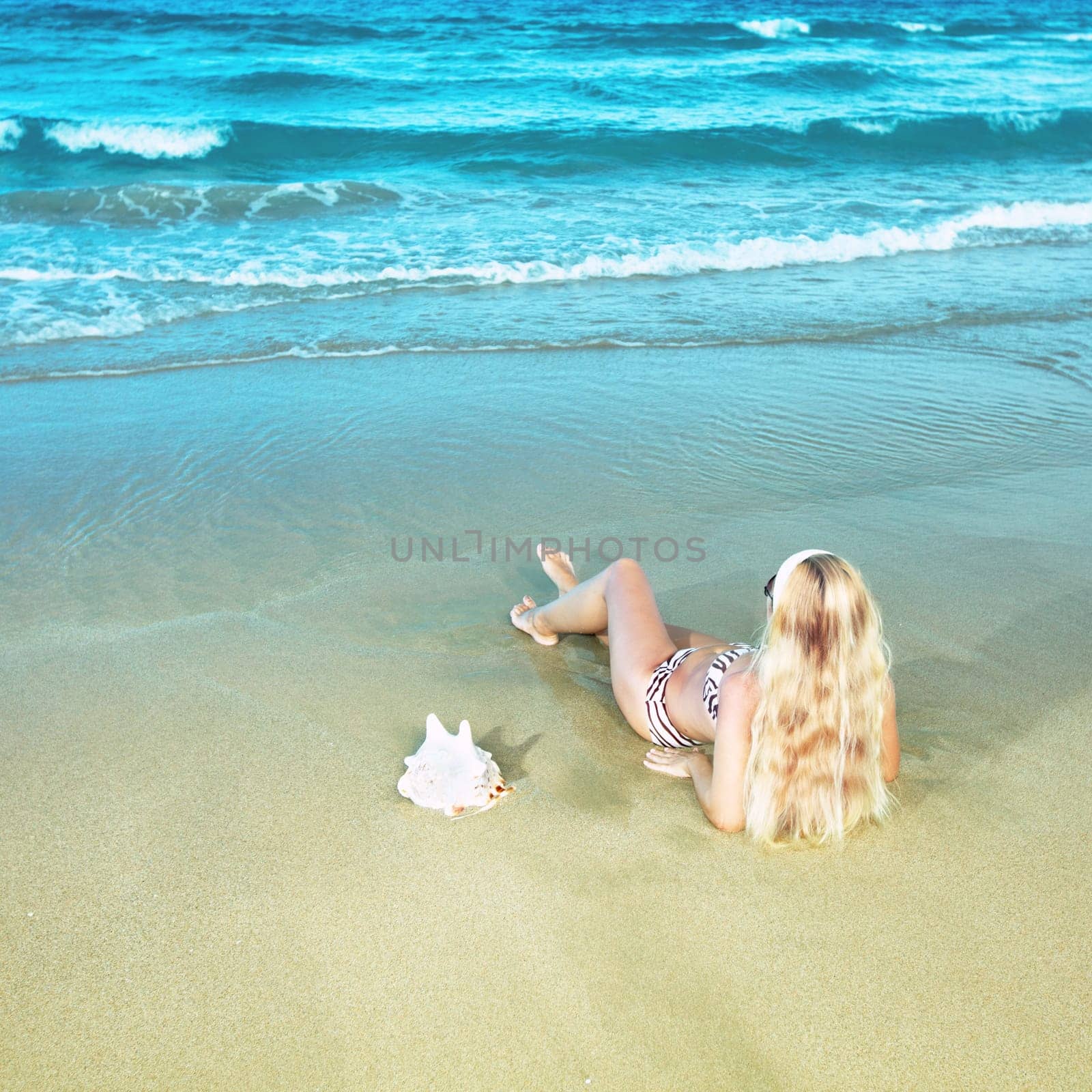 Young woman in bikini near the water