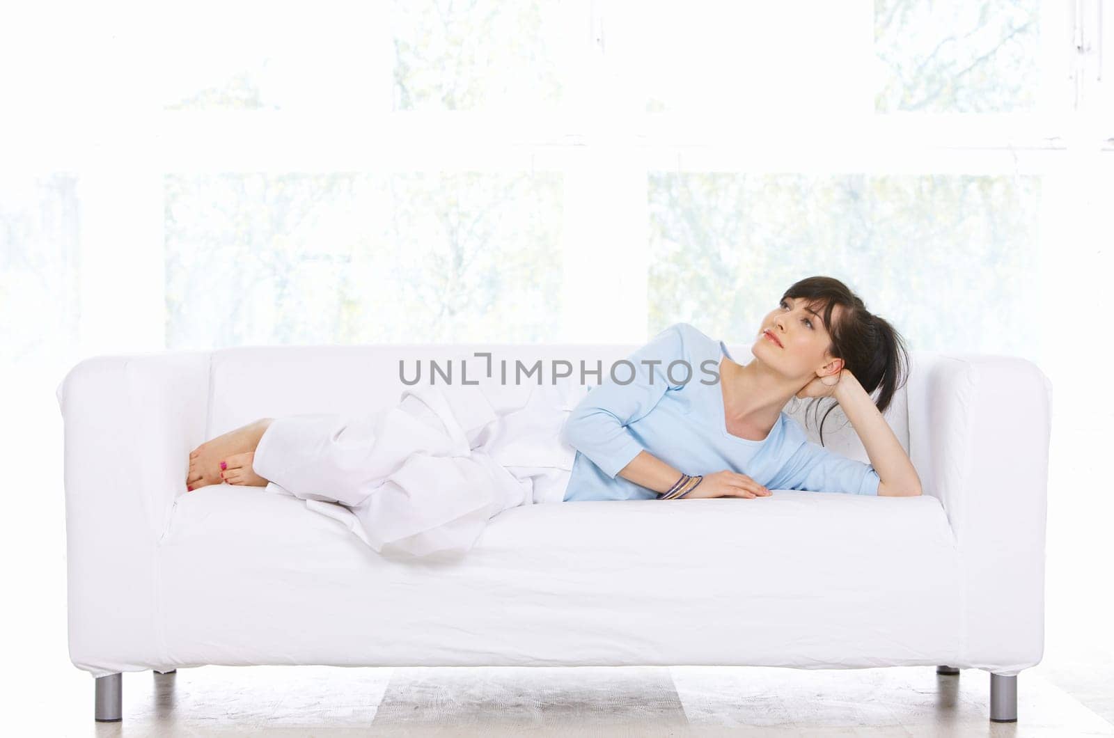 Young woman relaxing on couch in her home