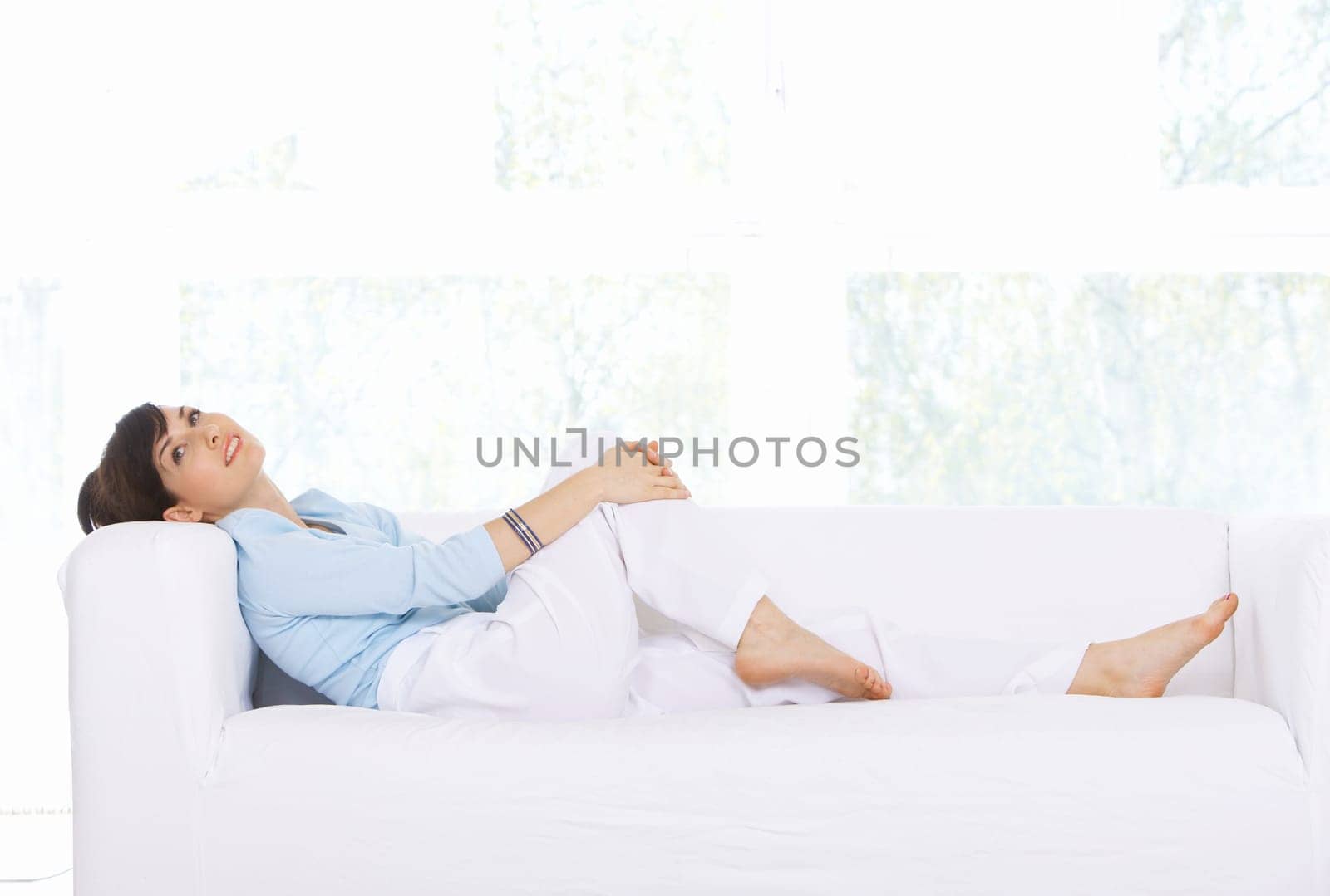 Young woman relaxing on couch in her home