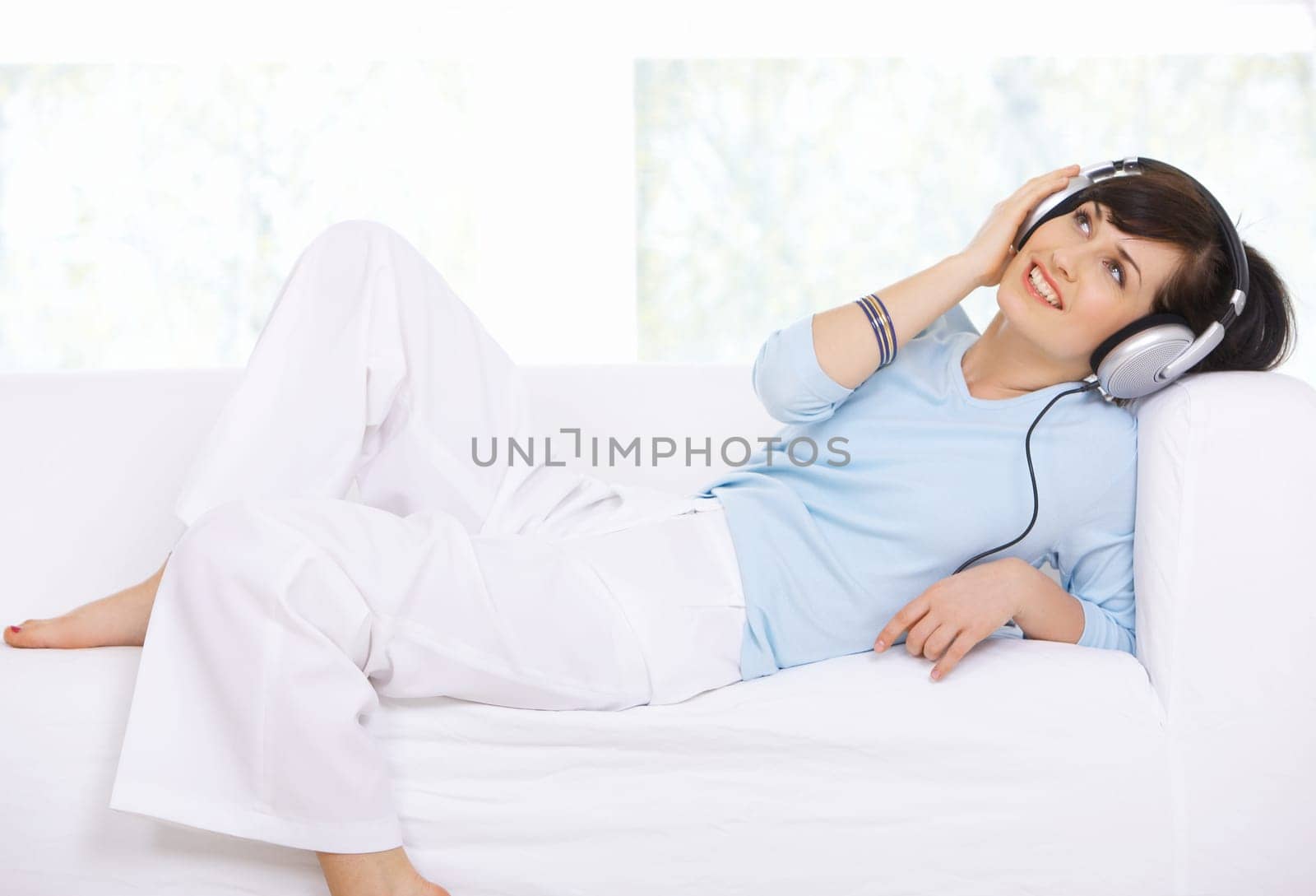 Young woman on couch and listen to the music
