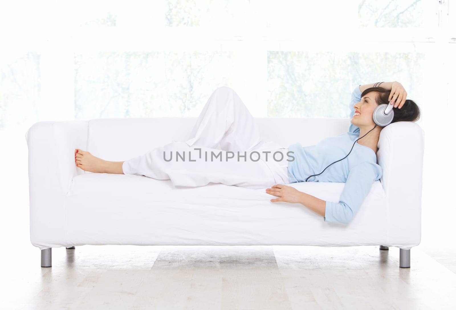 Young woman on couch and listen to the music