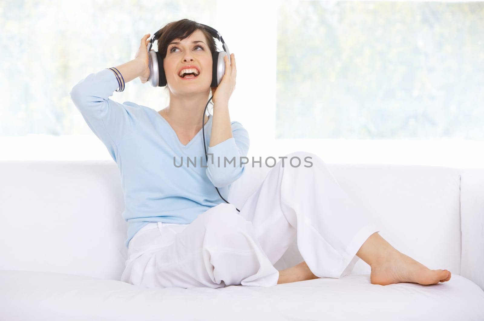 Young woman on couch and listen to the music