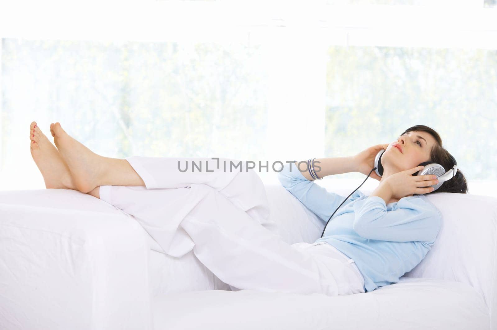 Young woman on couch and listen to the music