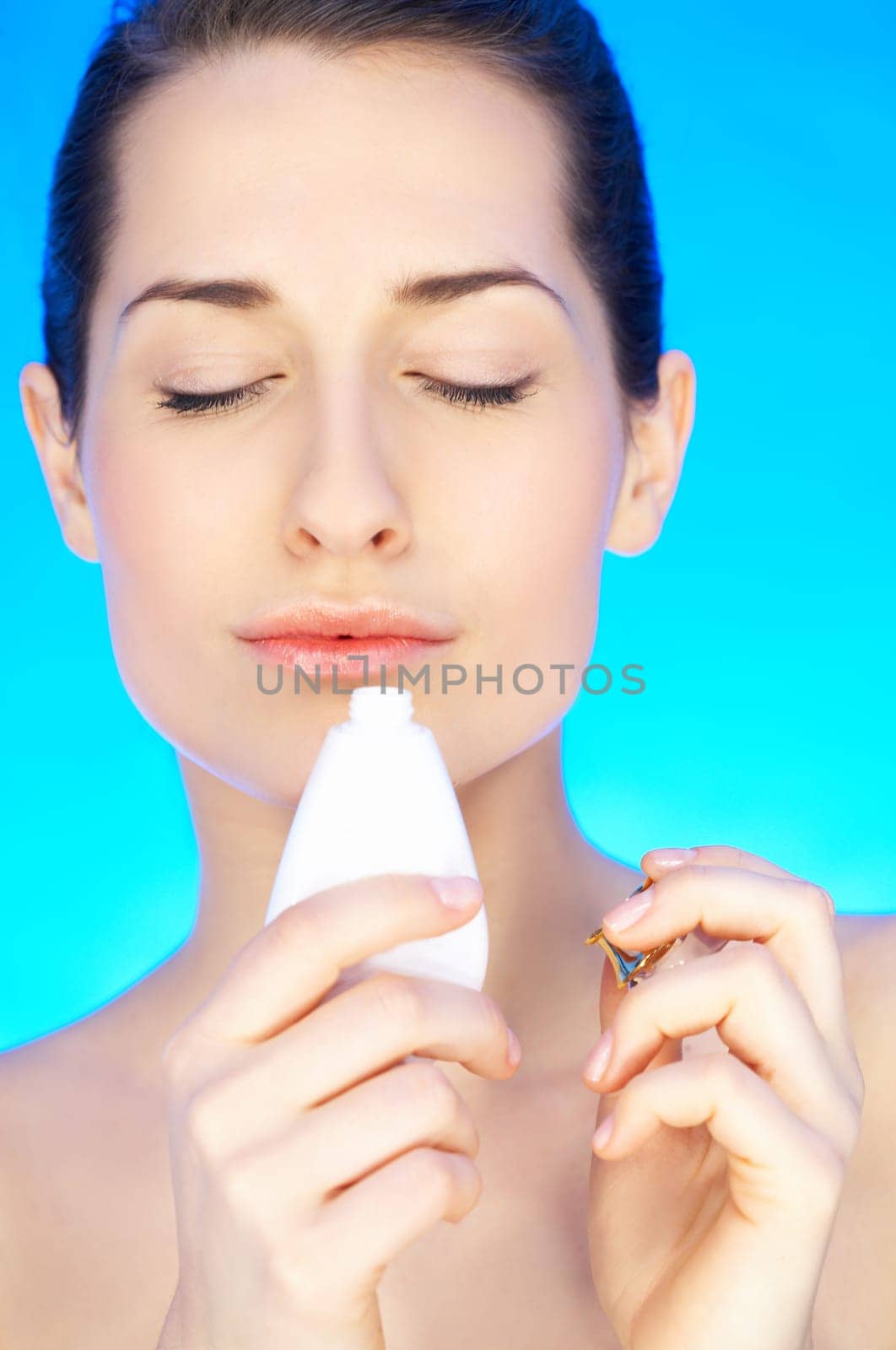 Portrait of 20-25 years old beautiful woman with bottle of perfume