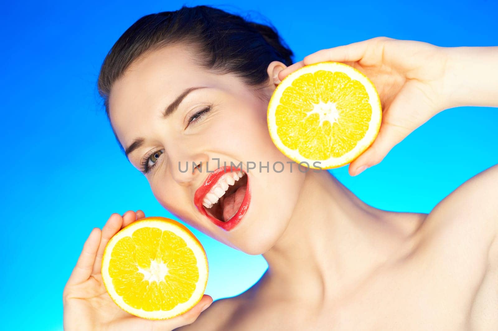 Portrait of beautiful woman with orange fruit