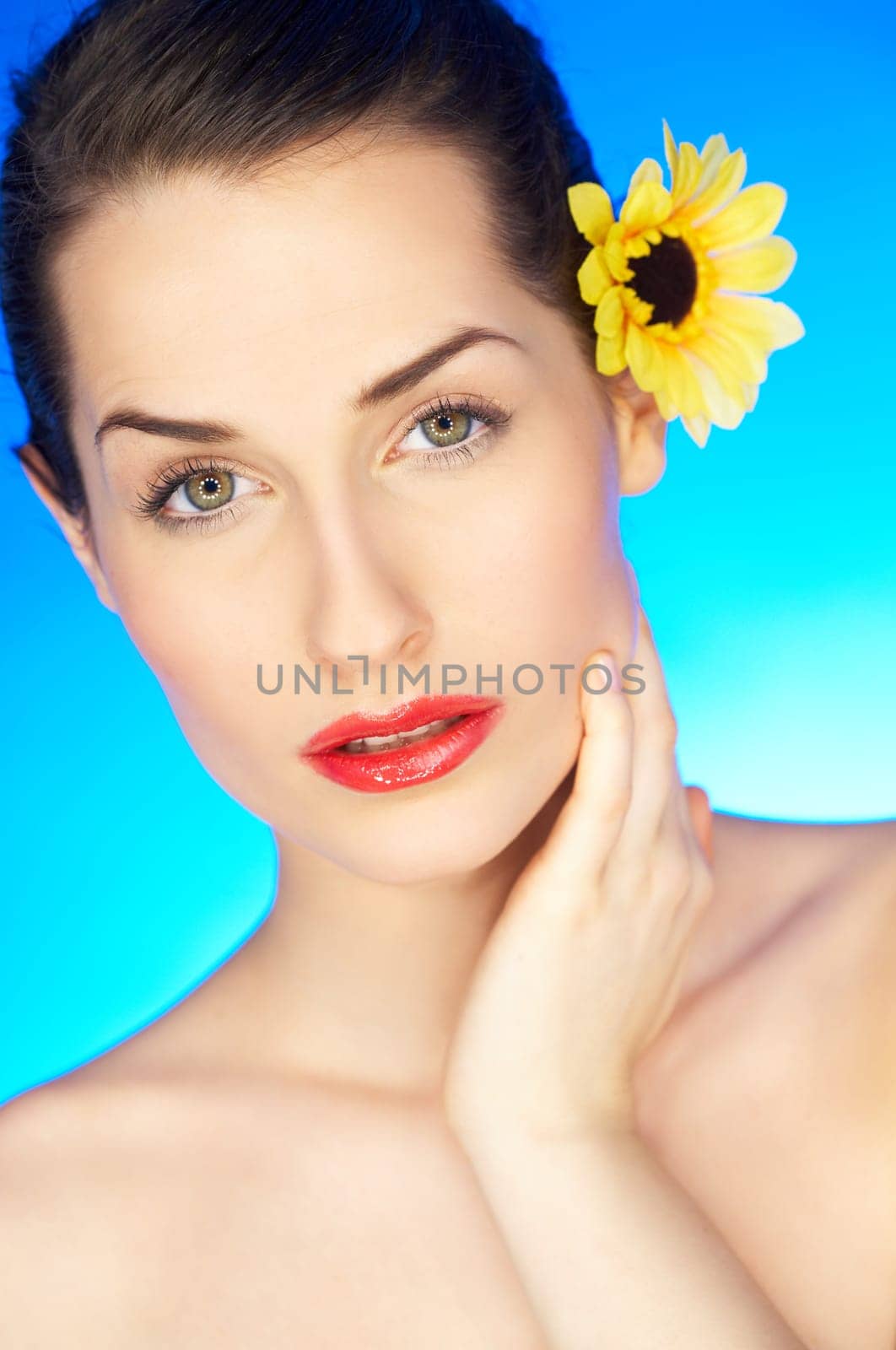 Portrait of beautiful woman with sunflower in hair