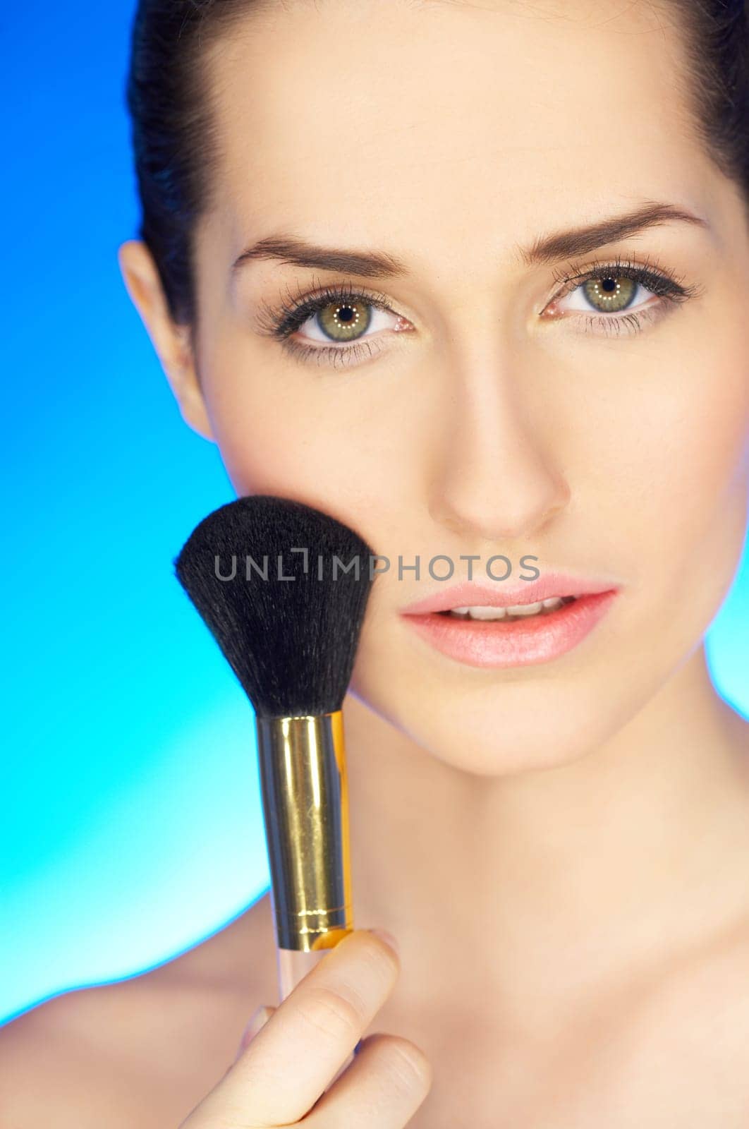 Portrait of beautiful woman with cosmetics brush