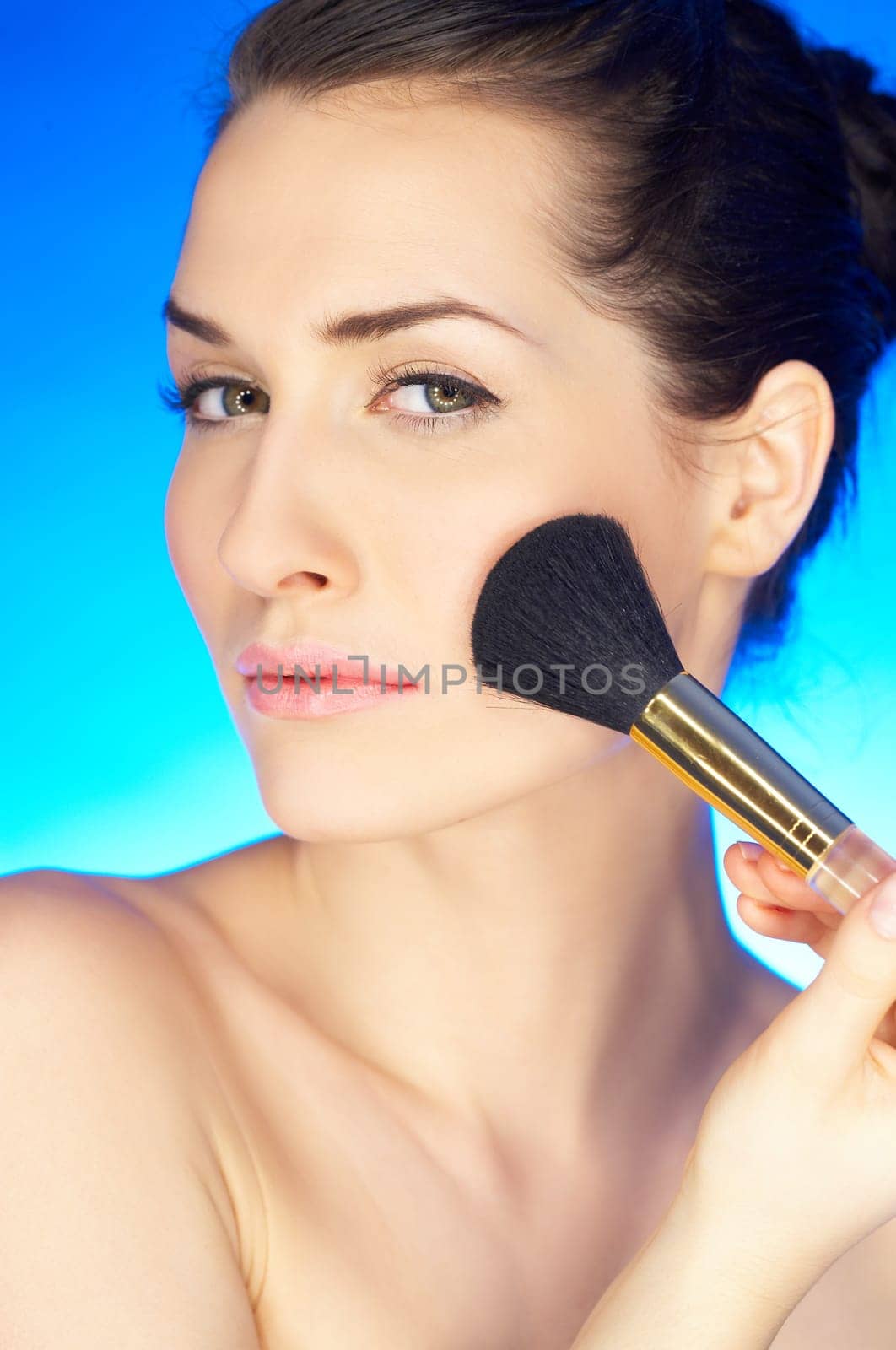 Portrait of beautiful woman with cosmetics brush