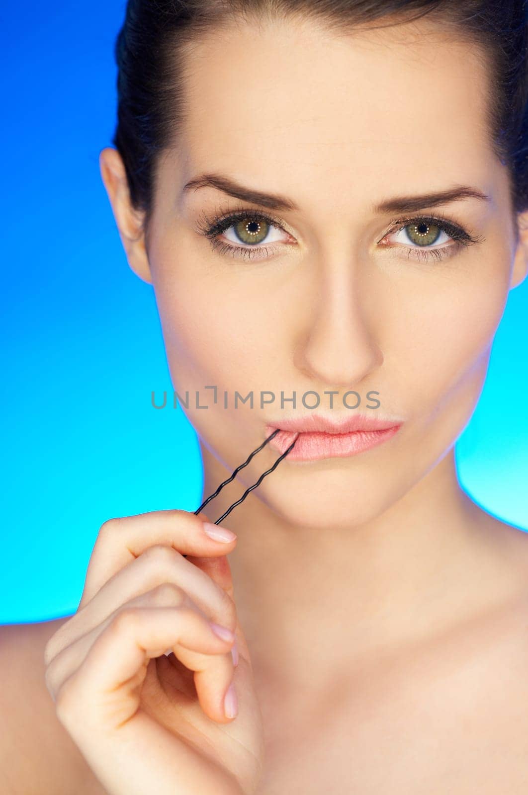 Portrait of beautiful woman with hairpin in mouth
