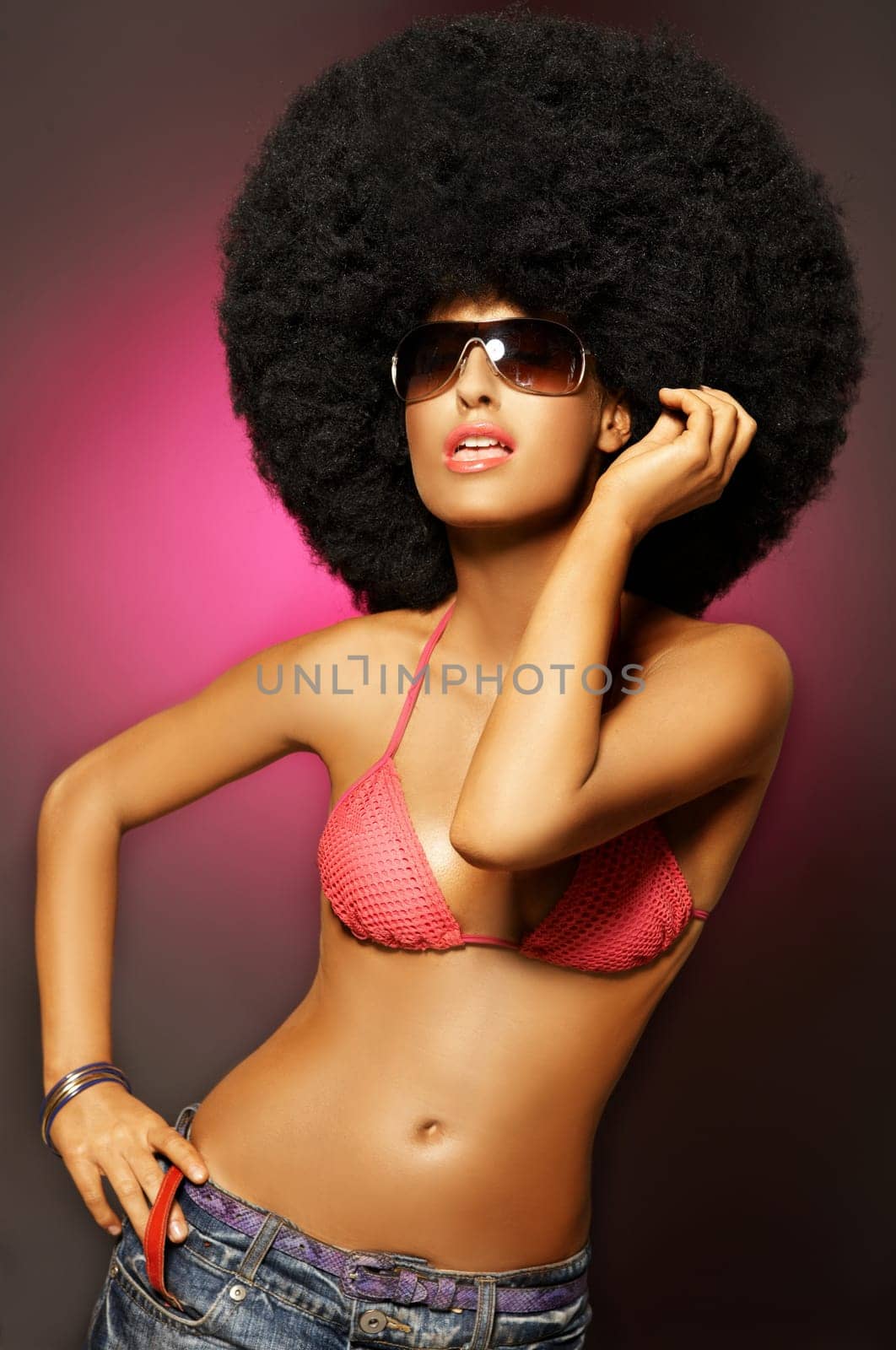 Beautiful woman with huge afro haircut on pink