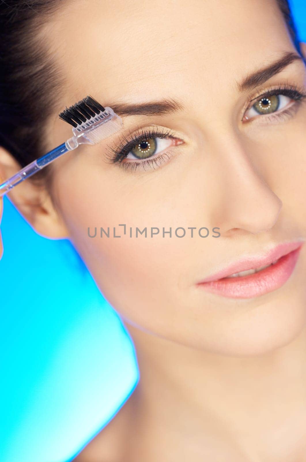 Portrait of beautiful woman is brushing her eyebrow
