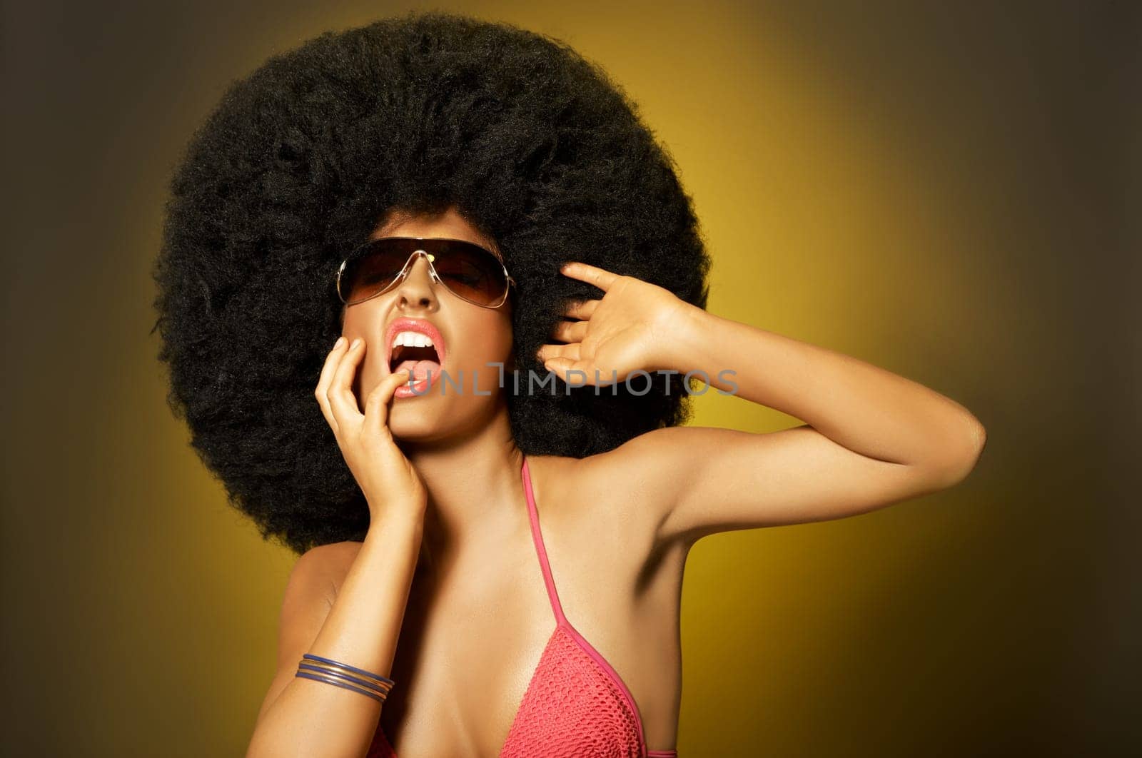 Beautiful woman with huge afro haircut on yellow